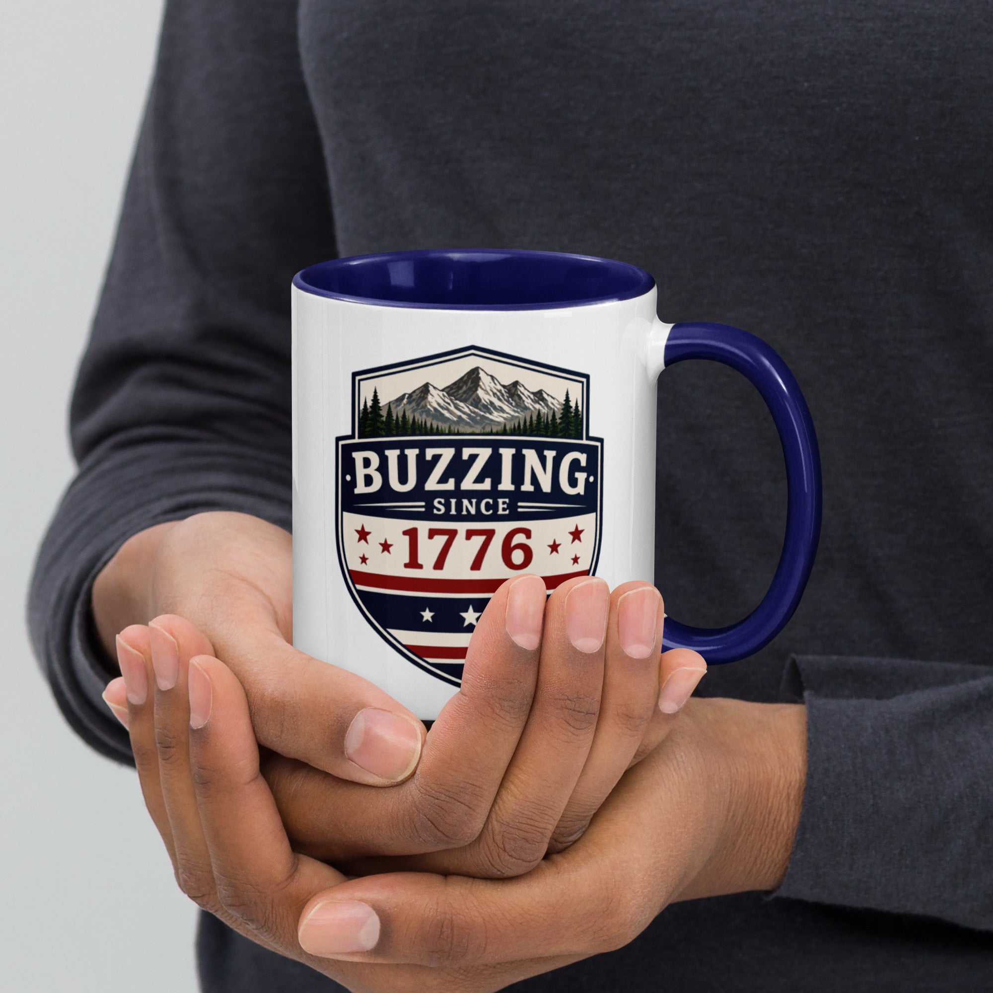 White mug with “Buzzing since 1776” graphic, dark blue interior and handle.