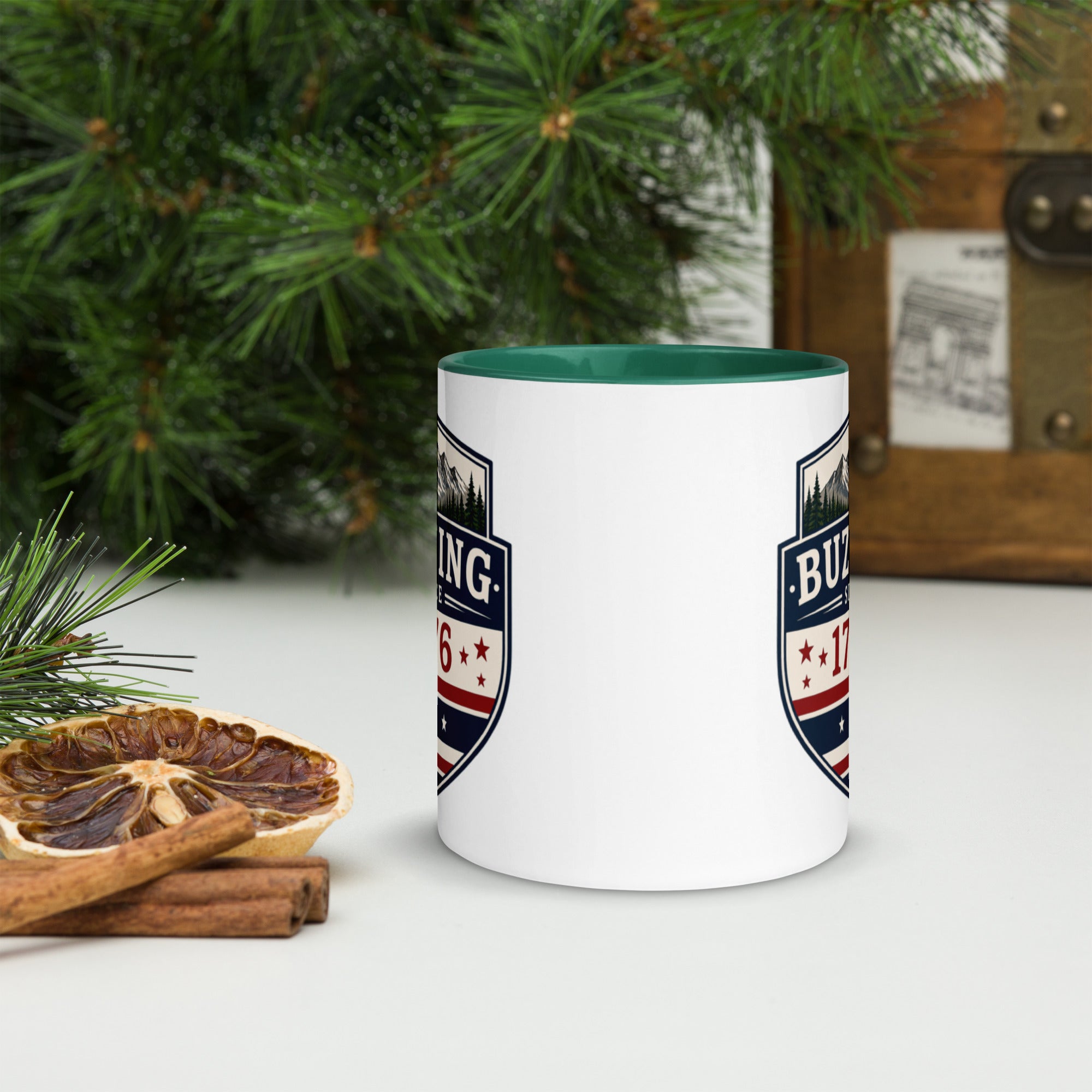White ceramic mug with printed badge design and green interior rim