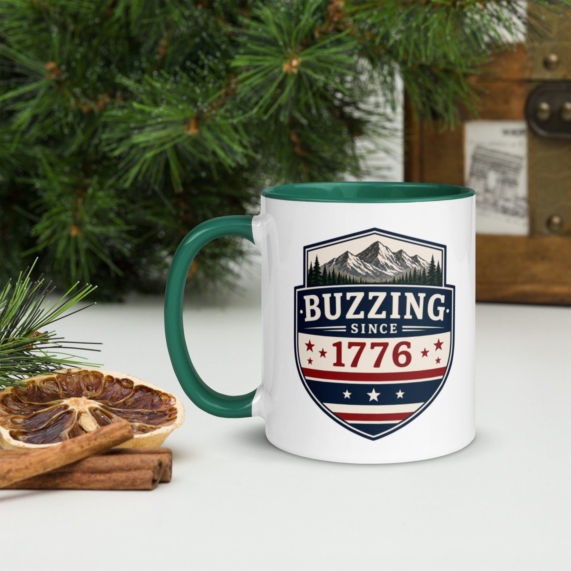 White ceramic mug with green rim and handle, shield logo reading 'Since 1776'