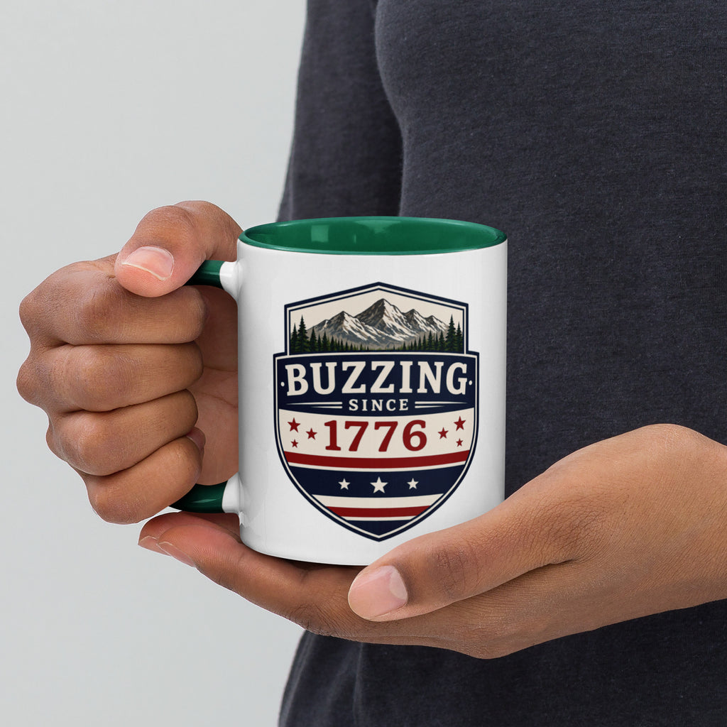 White ceramic mug with dark green interior, “Buzzing” 1776 crest graphic
