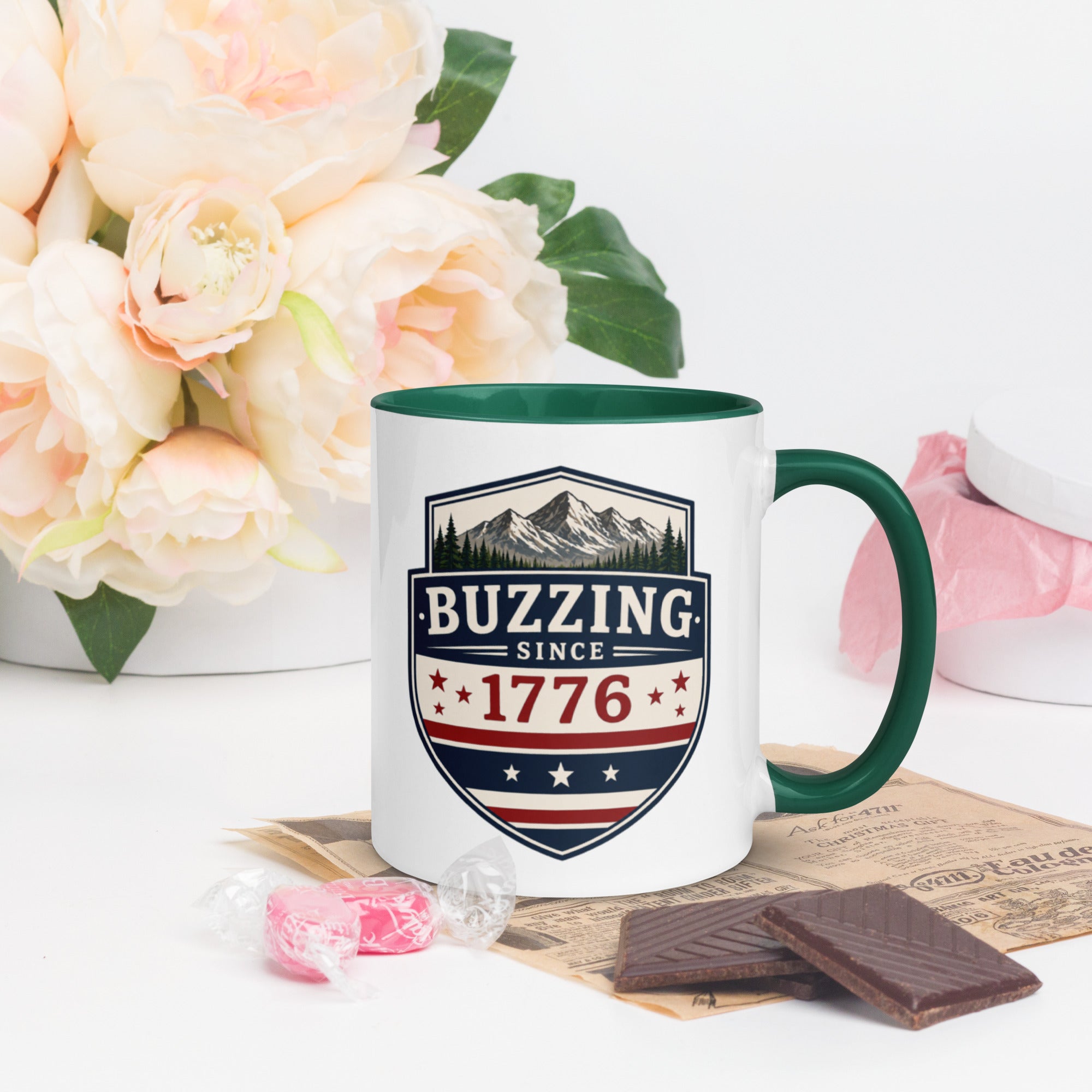 Ceramic mug with “1776” shield graphic, dark green rim and handle, white body.