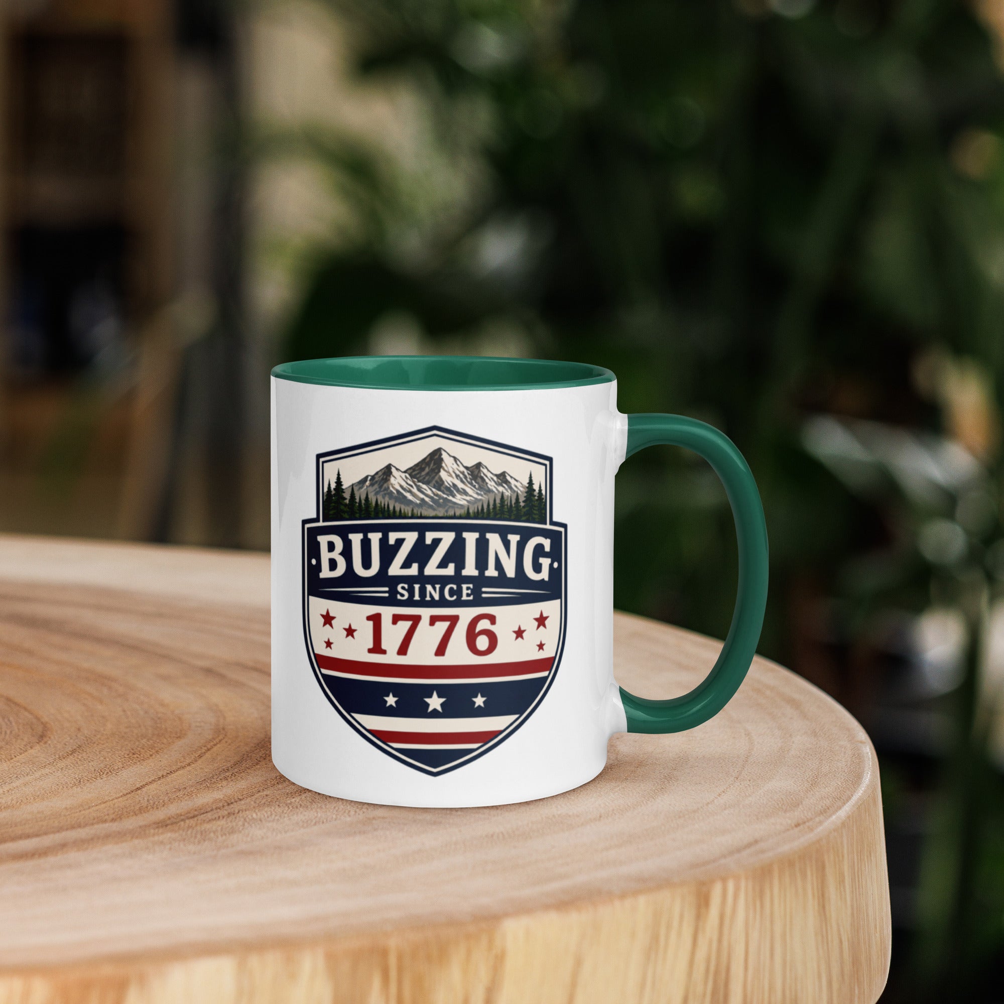 Coffee mug with dark green interior rim and handle, white body, “Buzzing Since 1776” graphic