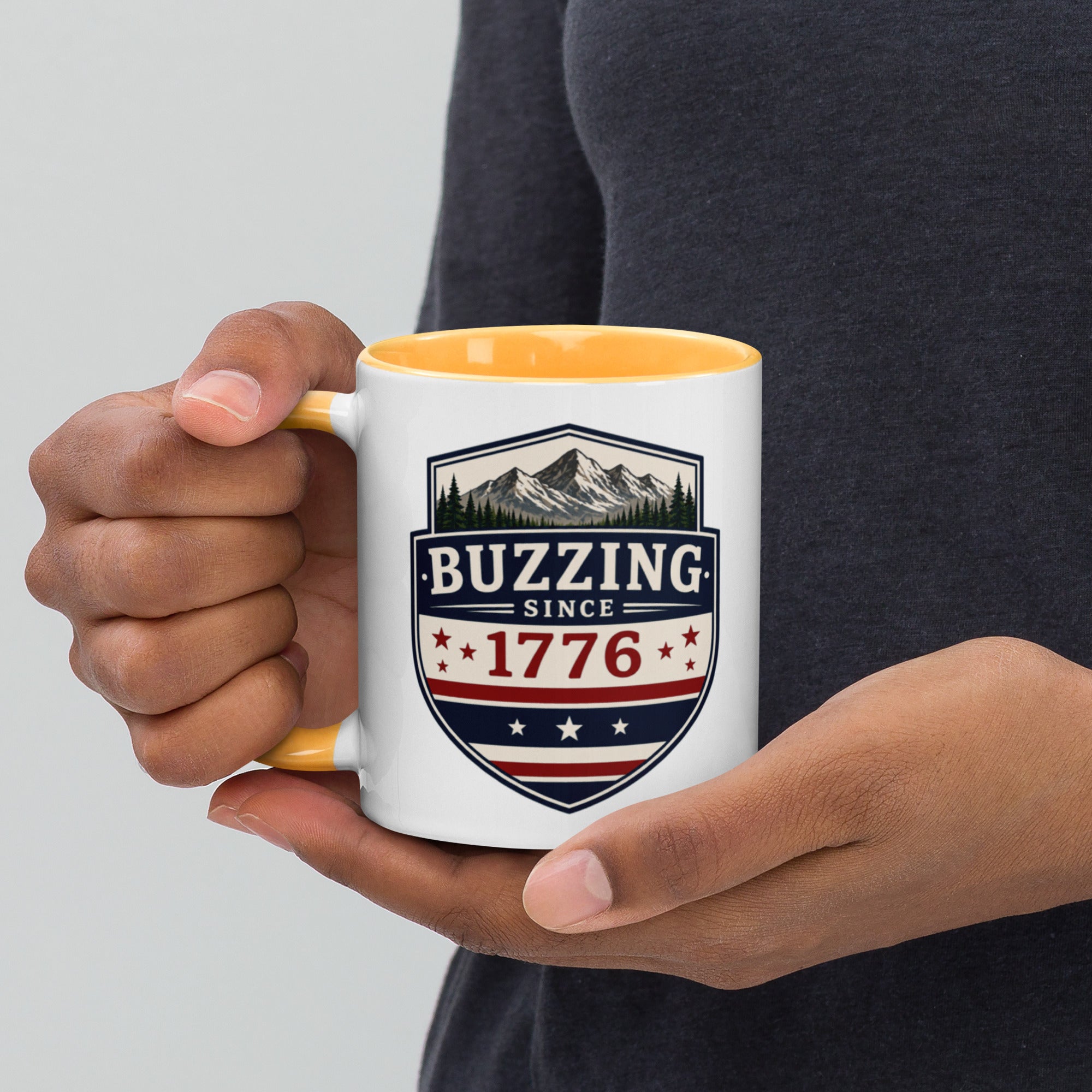 White ceramic mug with golden yellow interior, “Buzzing” 1776 crest graphic