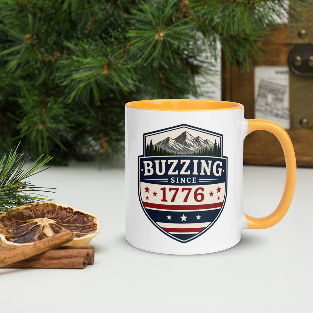 Ceramic mug with white body, golden yellow interior and handle, BUZZING Since 1776 badge
