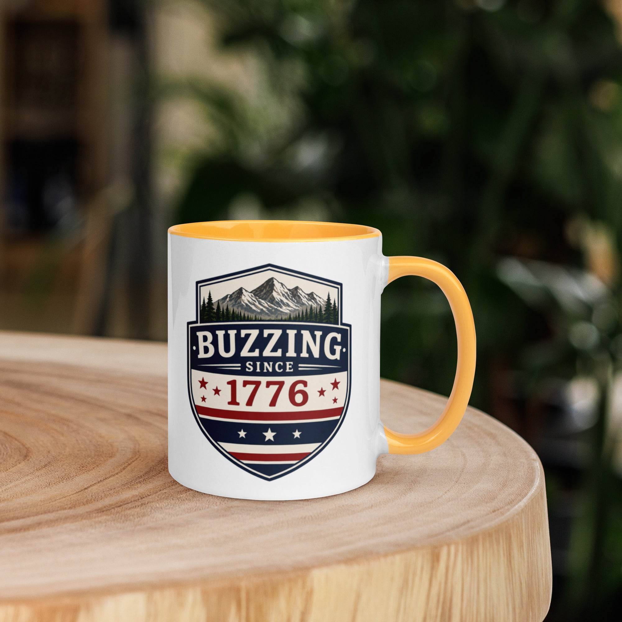 Coffee mug with golden yellow interior rim and handle, white body, “Buzzing Since 1776” graphic