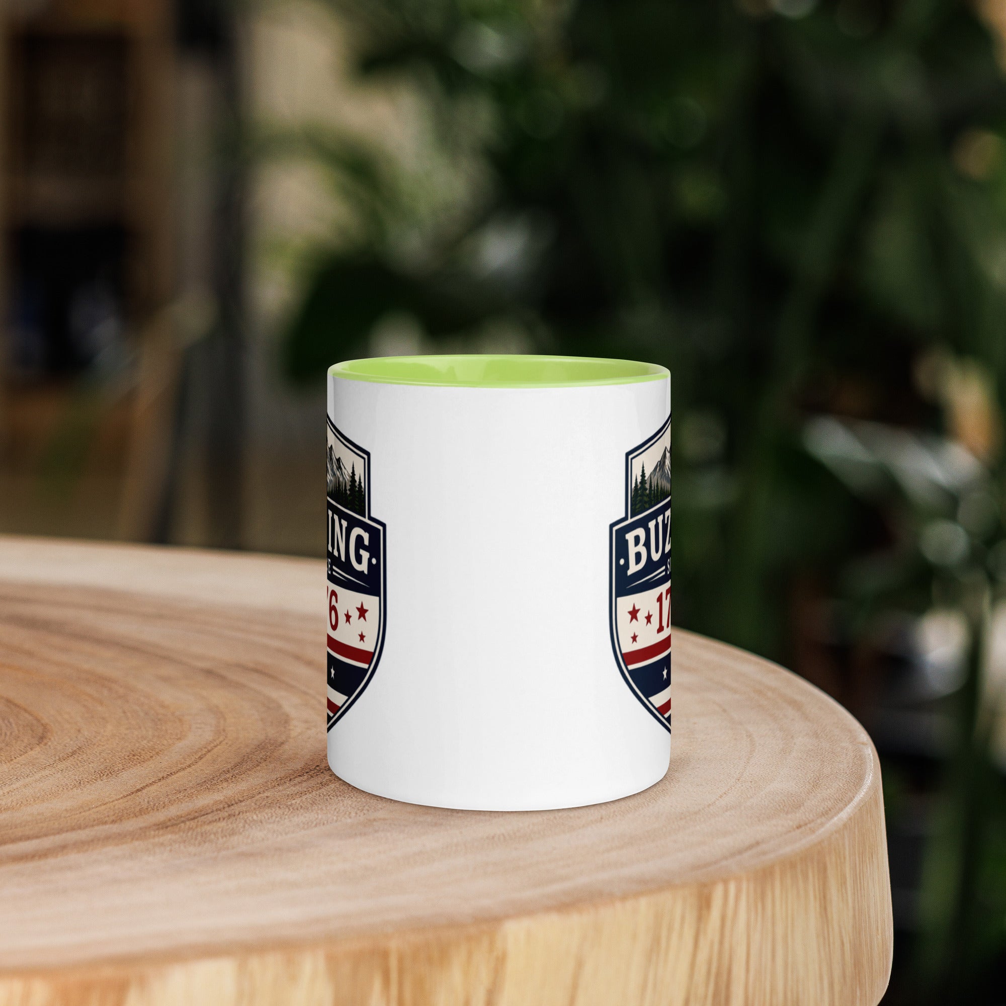 White coffee mug with green interior and blue-red emblem print on sides