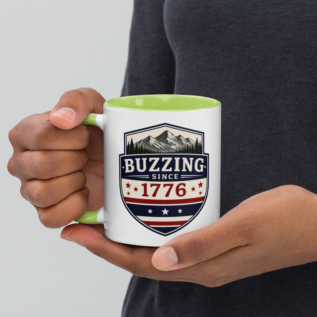 White ceramic mug with green interior, “Buzzing” 1776 crest graphic