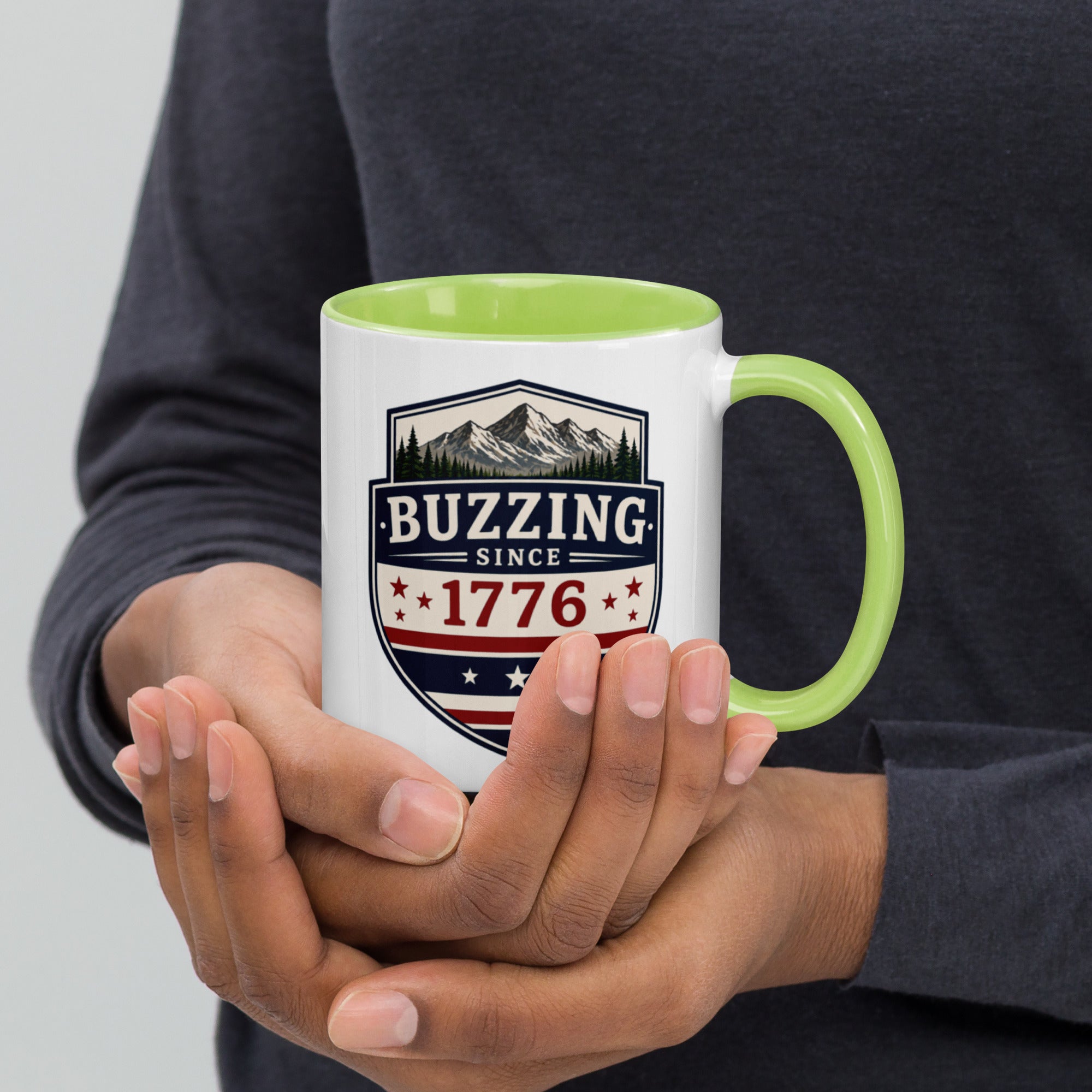 White mug with “Buzzing since 1776” graphic, light green interior and handle.