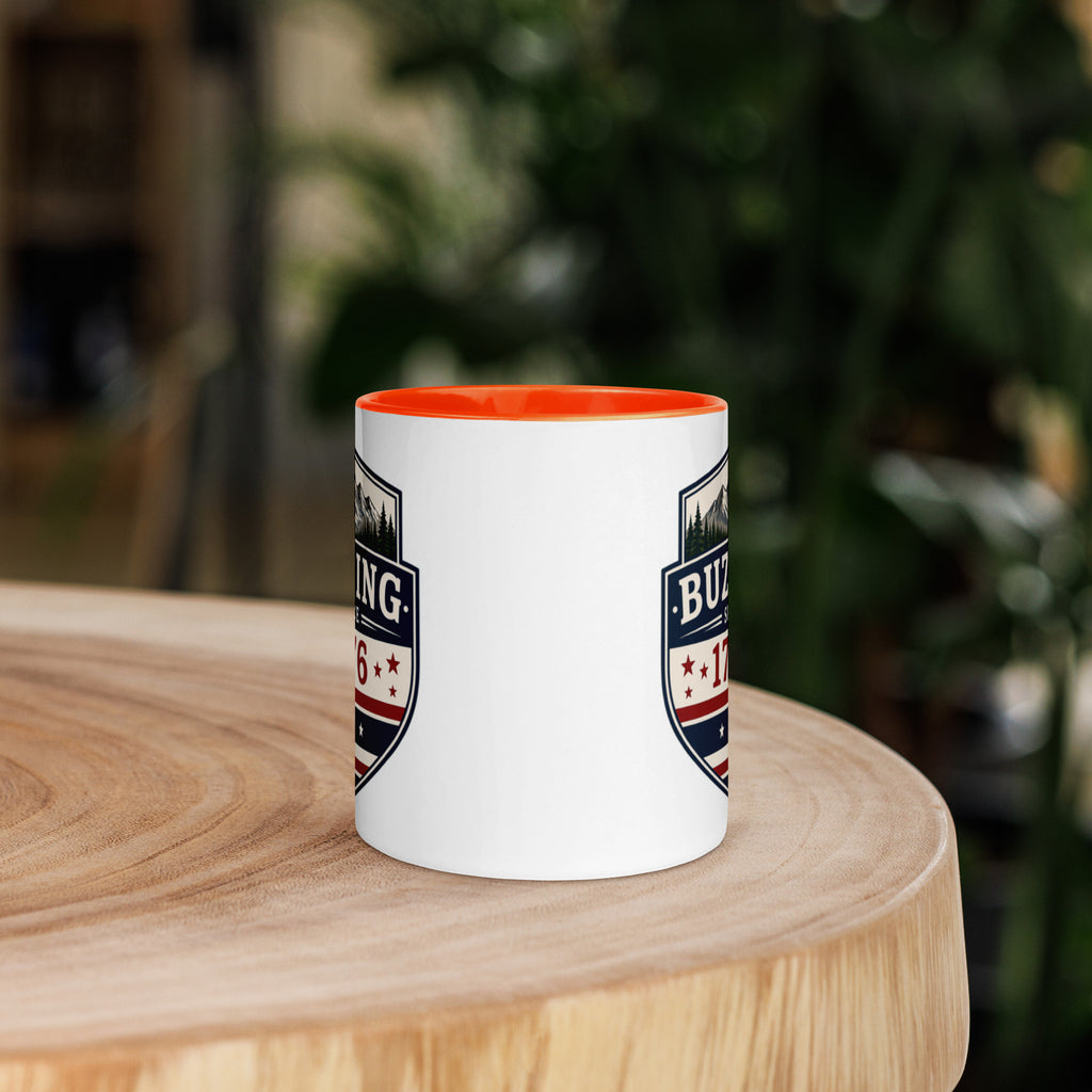 White coffee mug with orange interior and blue-red emblem print on sides