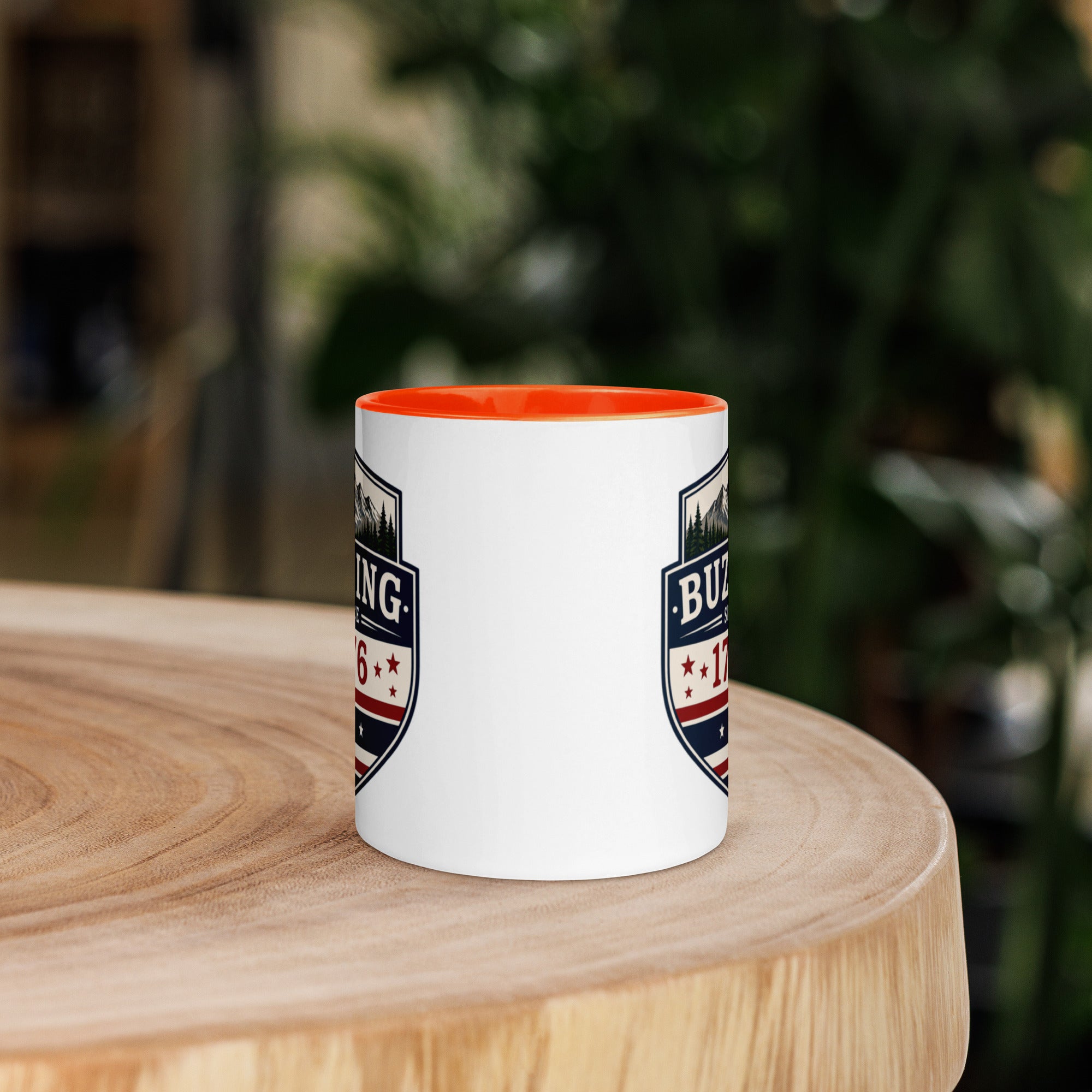 White coffee mug with orange interior and blue-red emblem print on sides
