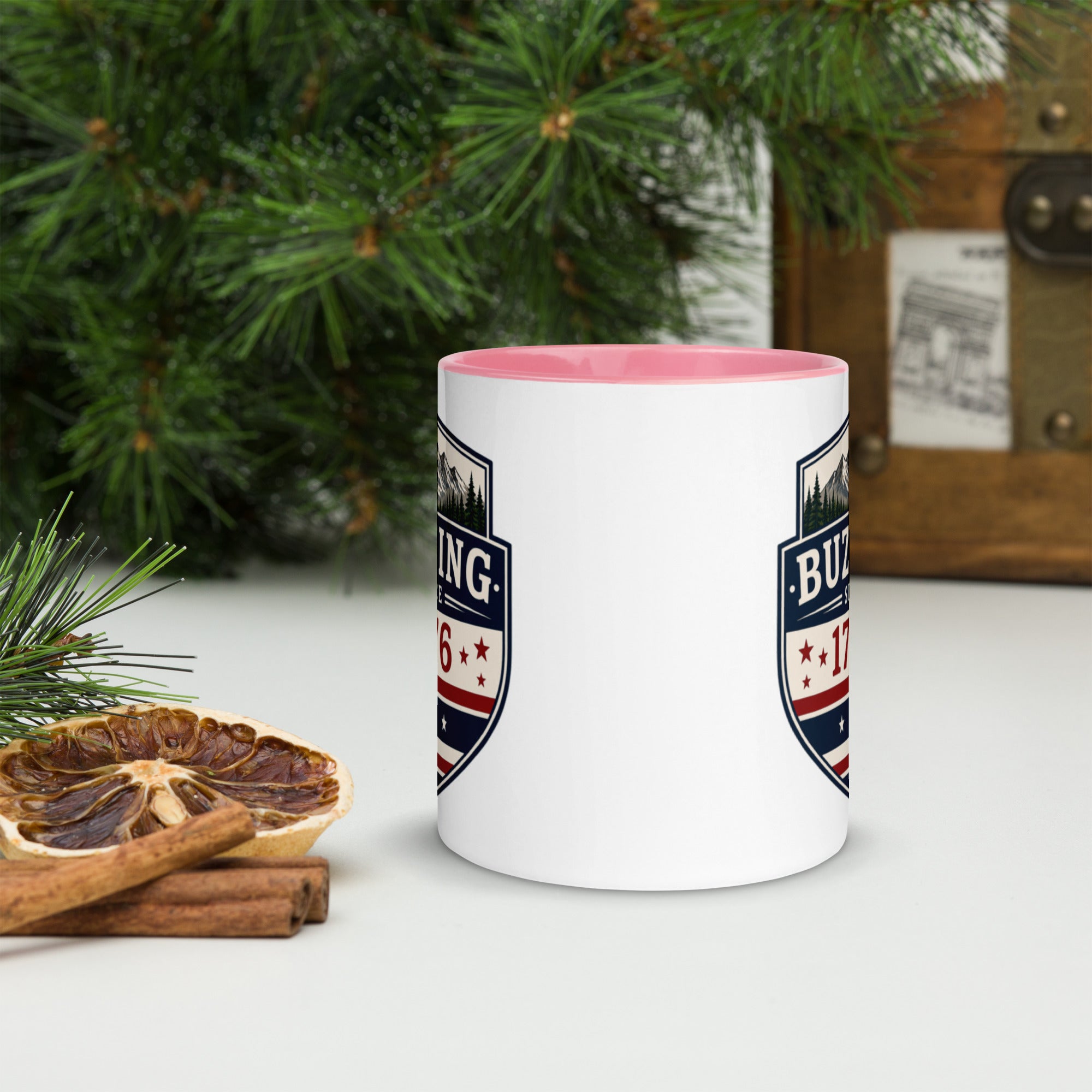 White ceramic mug with printed badge design and pink interior rim