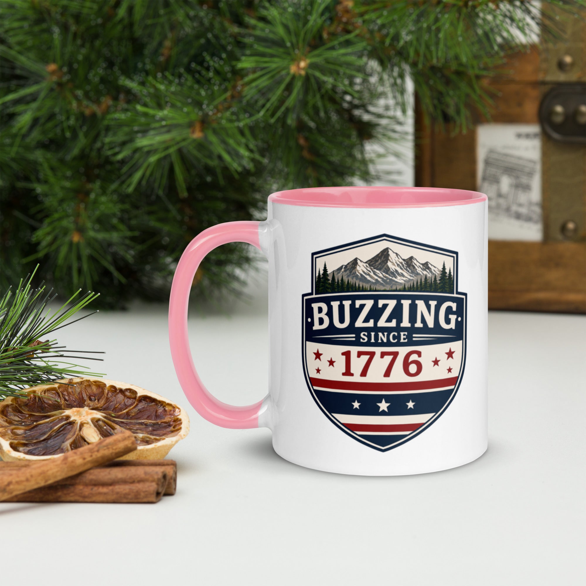 White ceramic mug with pink rim and handle, shield logo reading 'Since 1776'