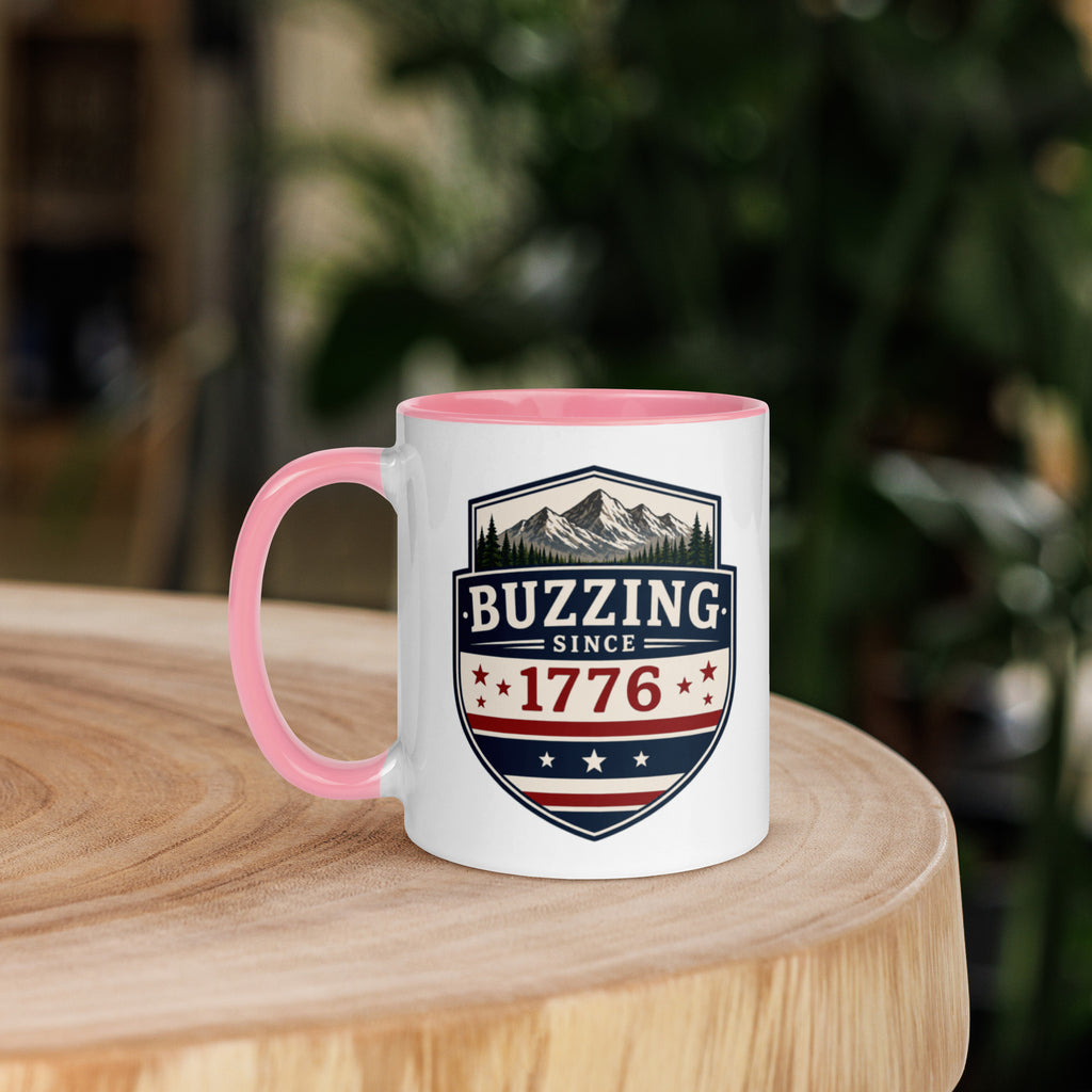 Mug with 'Buzzing Since 1776' crest, white body with pink handle and rim