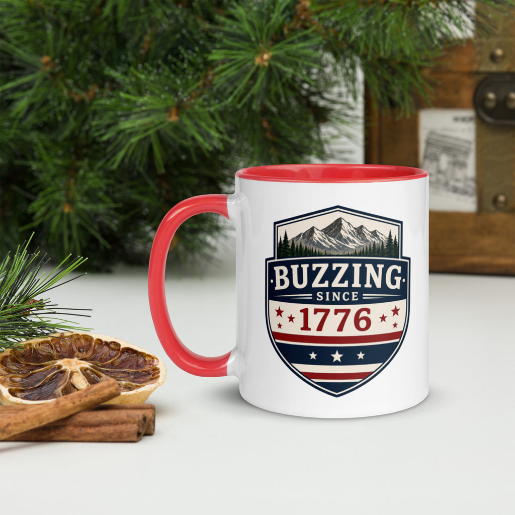 White ceramic mug with red rim and handle, shield logo reading 'Since 1776'