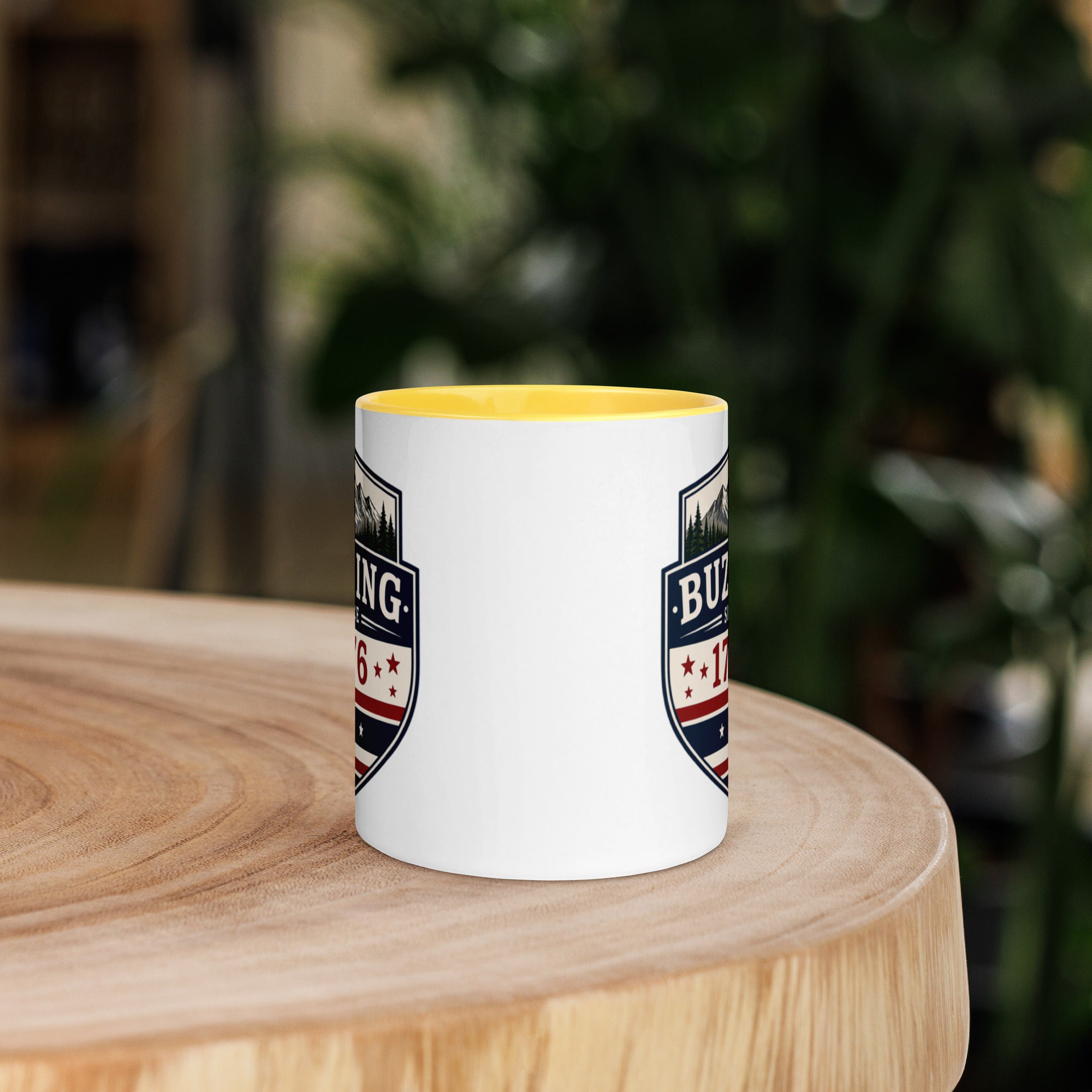 White coffee mug with yellow interior and blue-red emblem print on sides