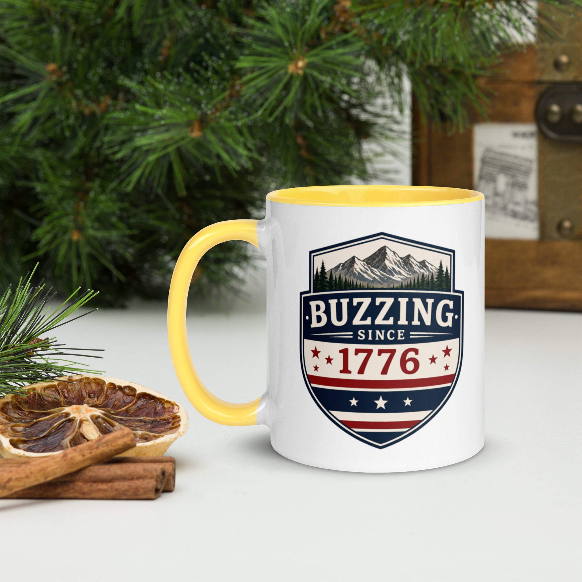 White ceramic mug with yellow rim and handle, shield logo reading 'Since 1776'