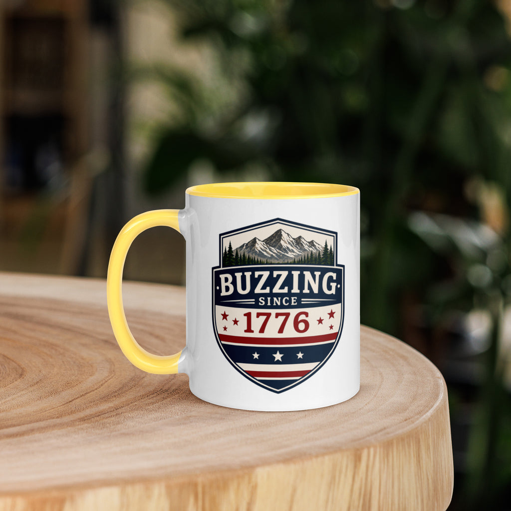 Mug with 'Buzzing Since 1776' crest, white body with yellow handle and rim