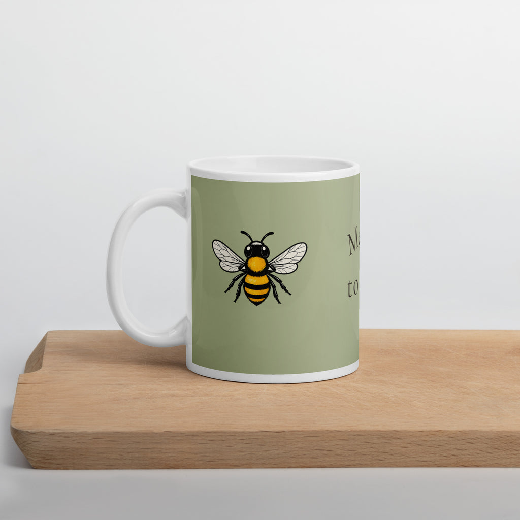 Sage green ceramic coffee mug with bee illustration and white handle