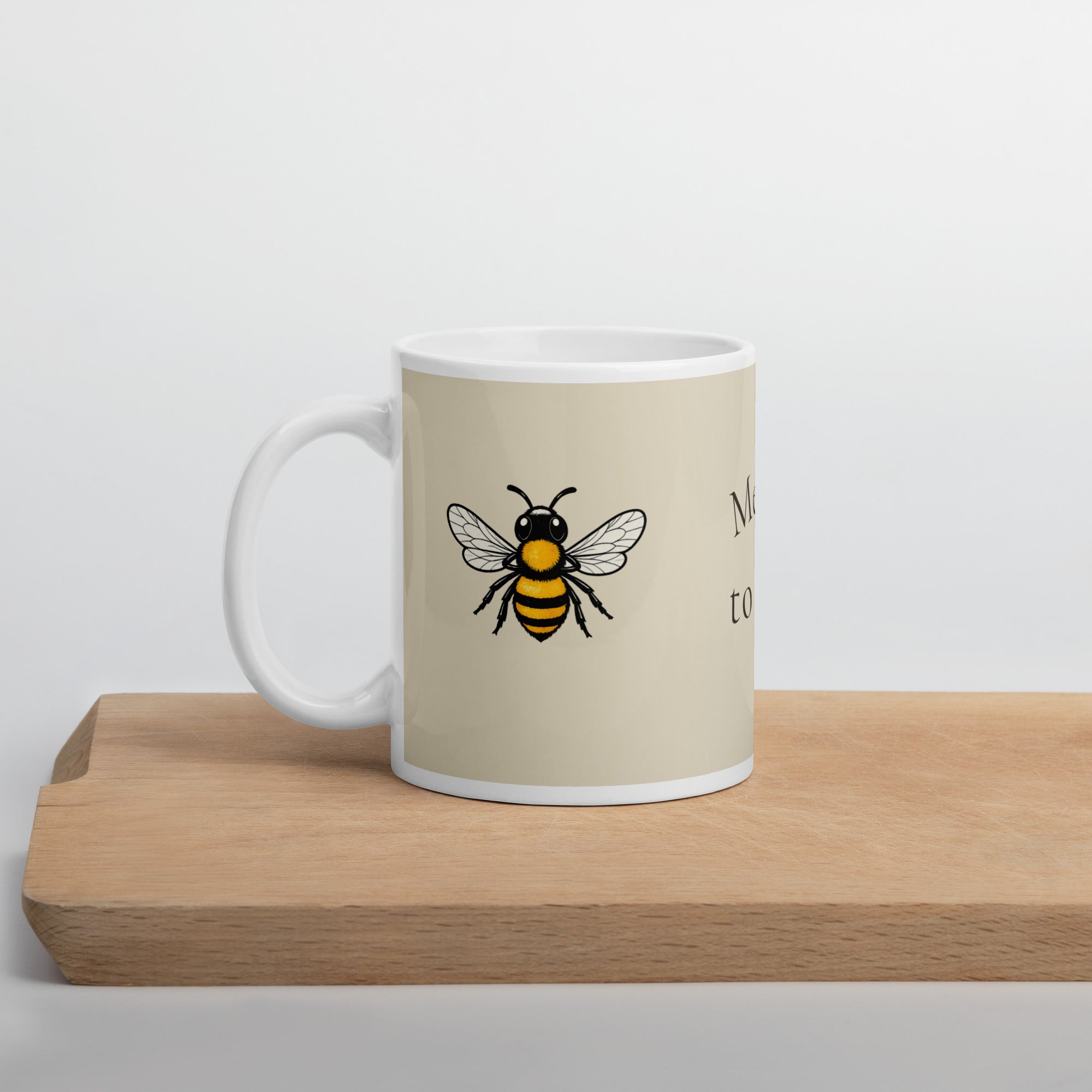 Light beige ceramic coffee mug with bee illustration and white handle