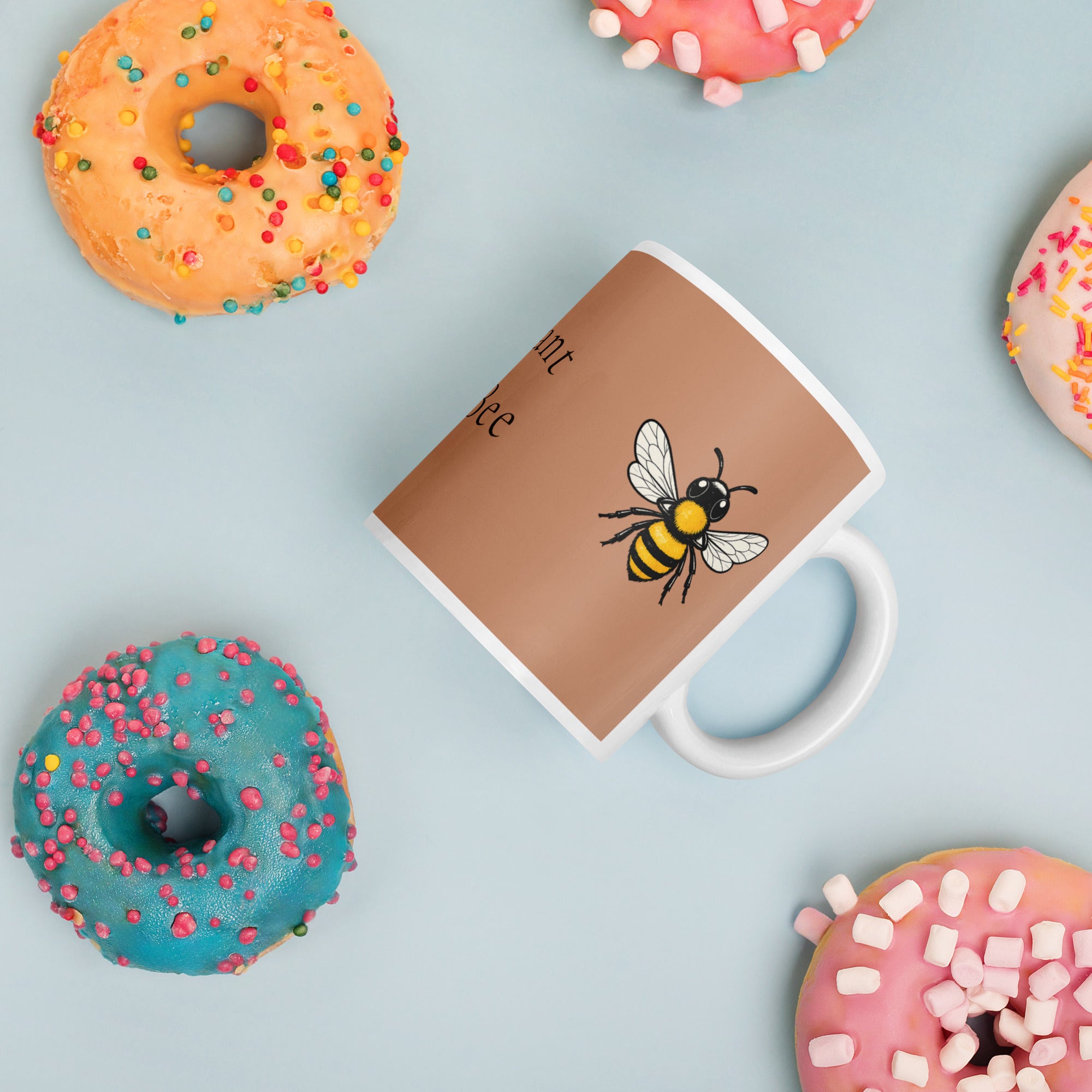 Brown ceramic mug with white rim and handle, bee illustration; top view
