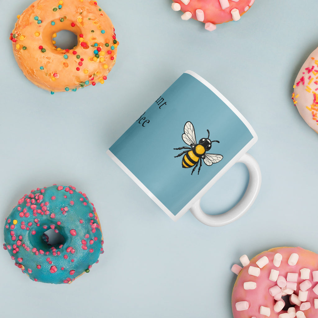 Blue ceramic mug with bee illustration and white handle, angled view