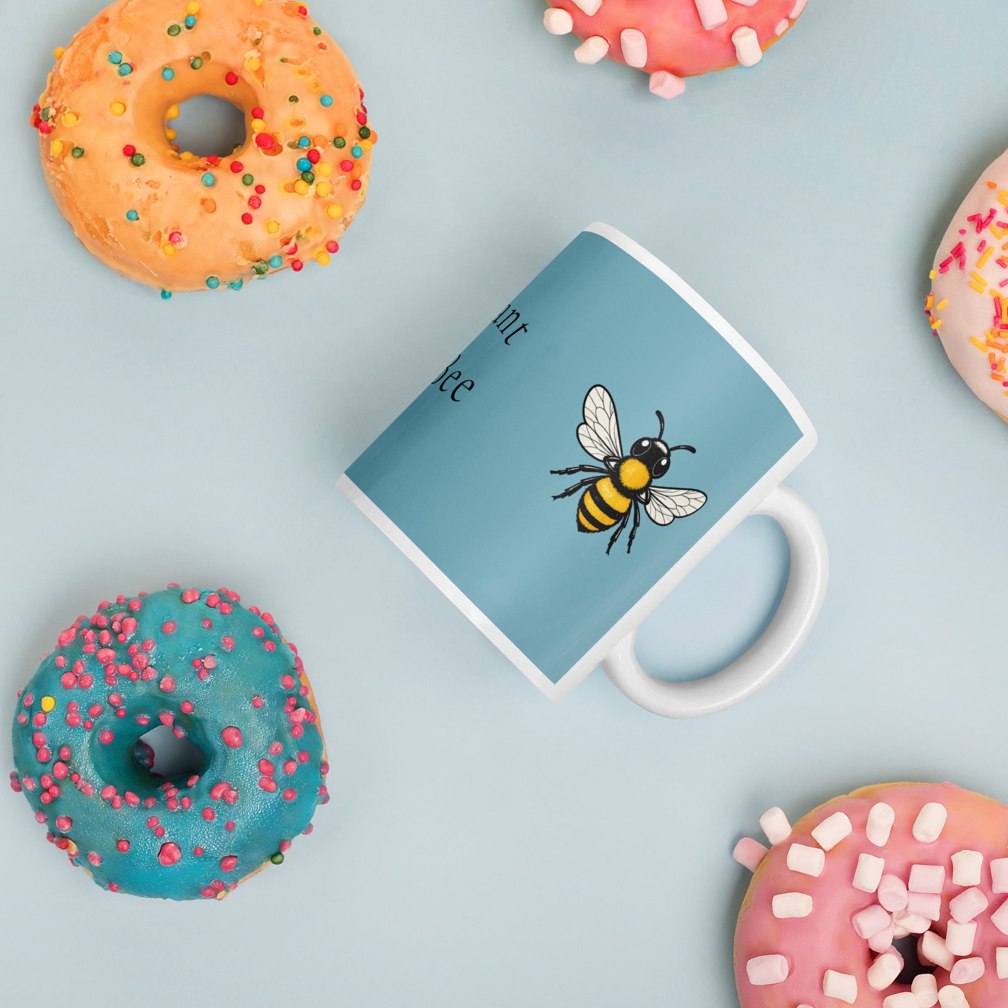 Blue ceramic mug with bee illustration and white handle, angled view