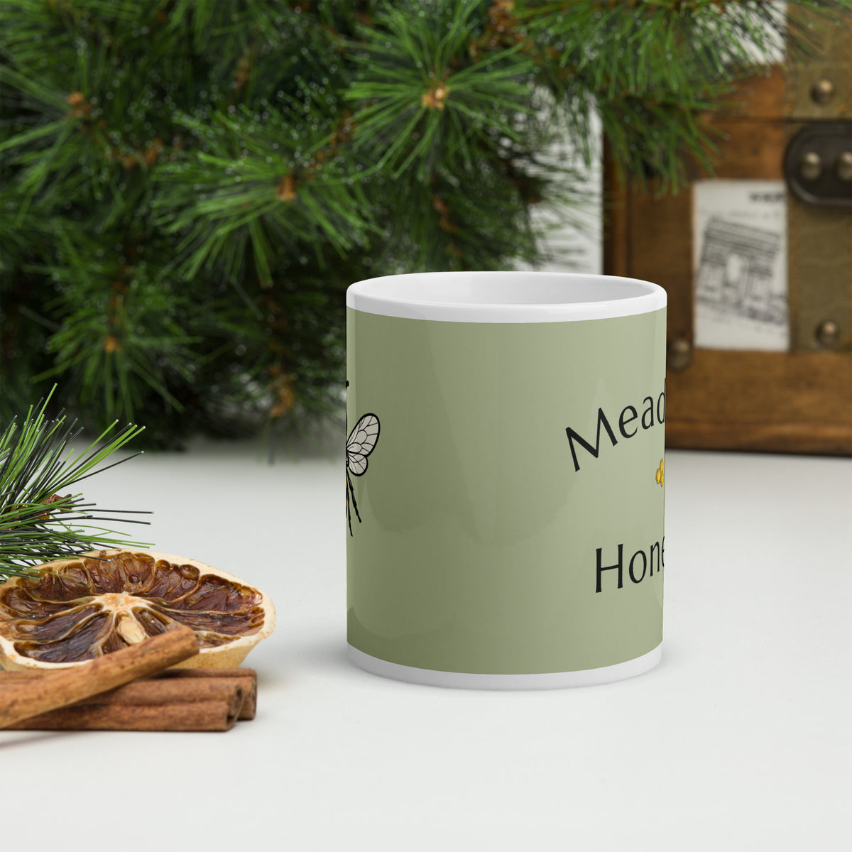 Green ceramic mug side view with honeybee line art and partial Meadow Honey text