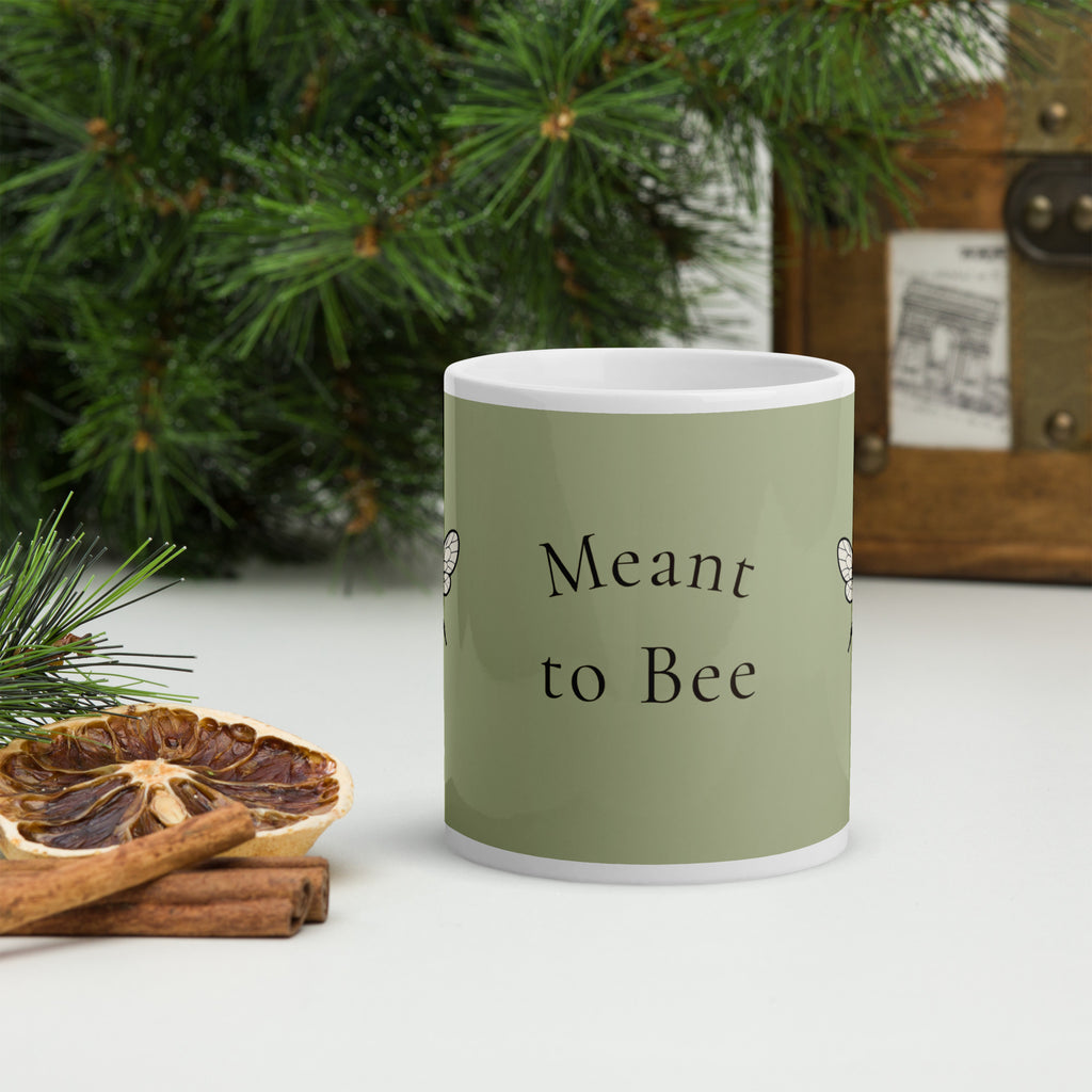Sage green ceramic mug with 'Meant to Bee' text on front and white handle