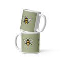 Sage green ceramic coffee mug set, white handle, black-and-yellow bee illustration