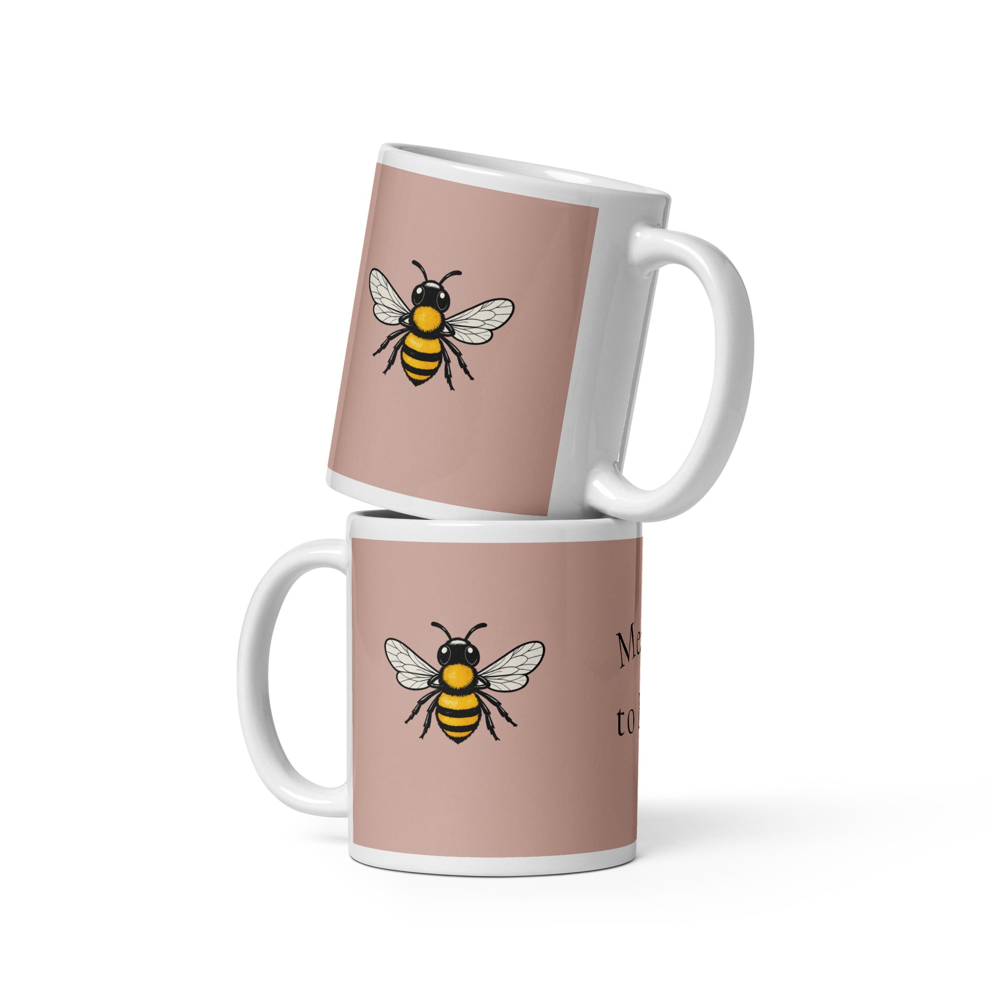 Dusty rose ceramic mug with white rim and handle, showing a bee illustration on the side.