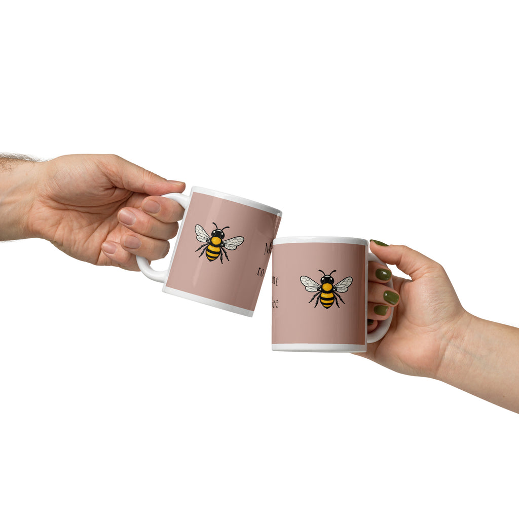Pair of dusty rose ceramic mugs with bee illustrations and white interiors