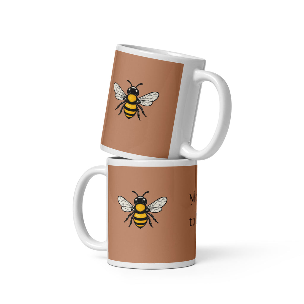 Two stacked brown ceramic coffee mugs with bee illustrations and white handles
