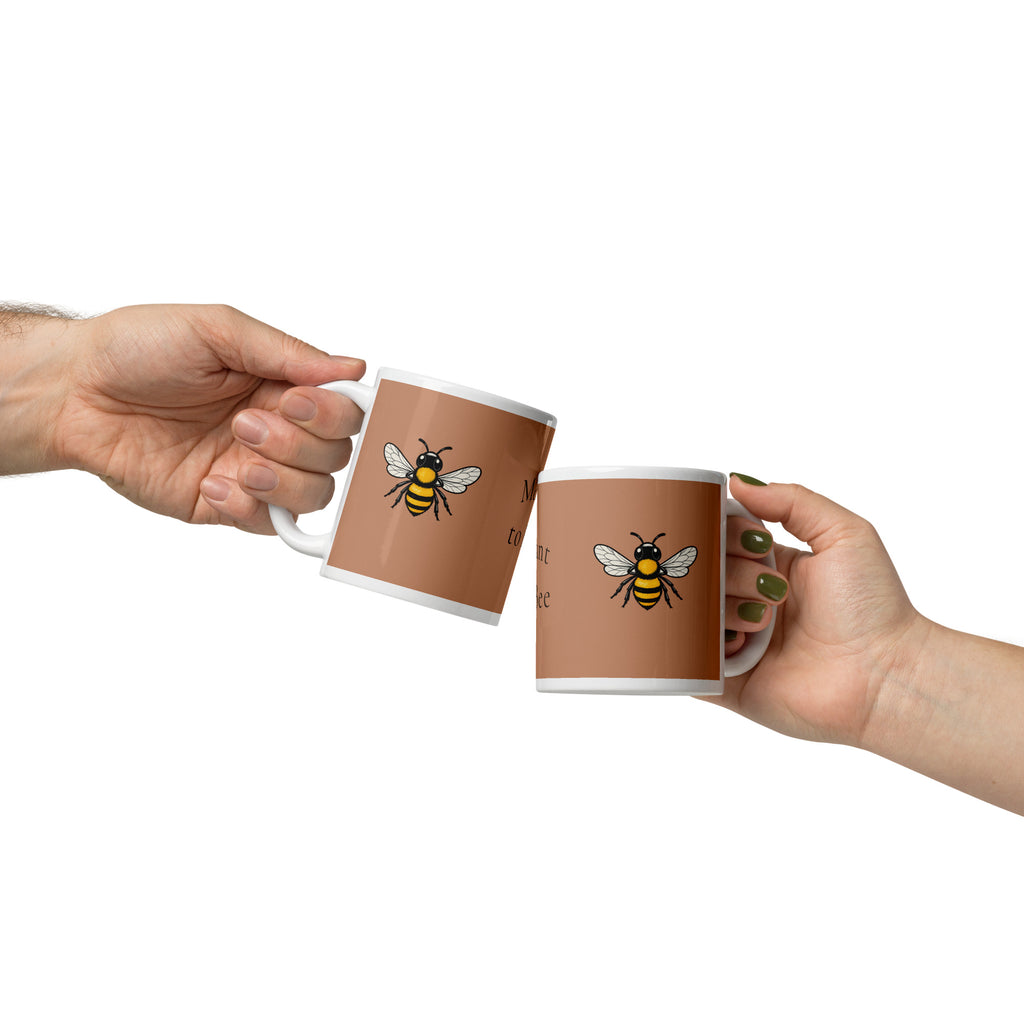 Two brown ceramic mugs with bee illustration, held up by two people
