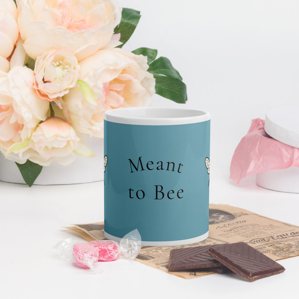 Blue ceramic coffee mug with 'Meant to Bee' wording, white rim and handle.