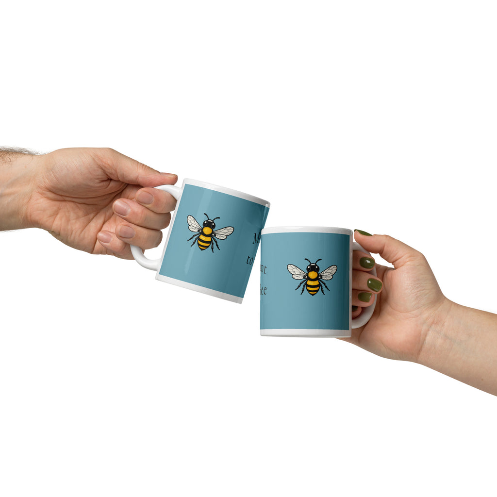 Blue ceramic coffee mug with bee illustration, white handle and rim