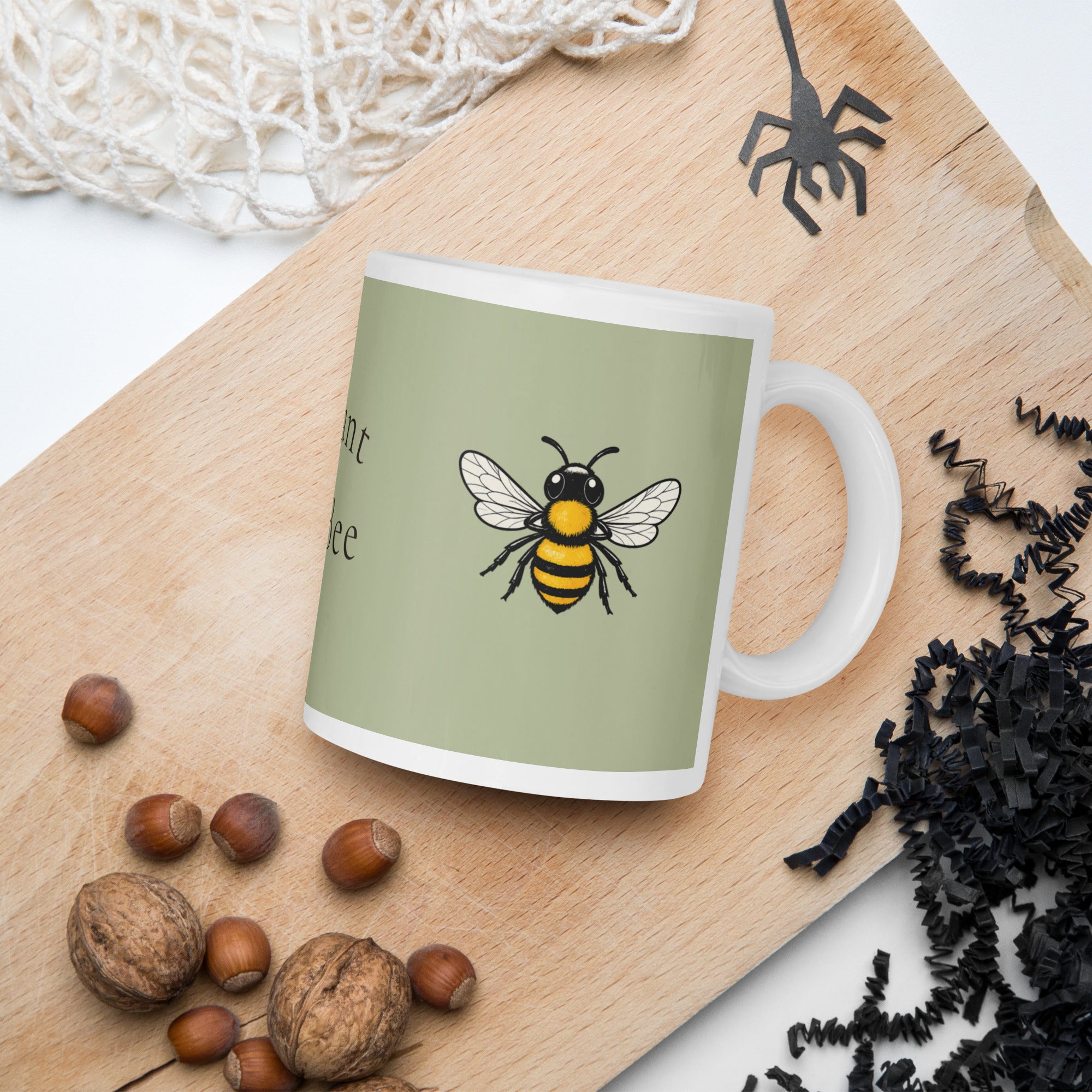 Sage green ceramic mug with bee illustration and partial phrase on front