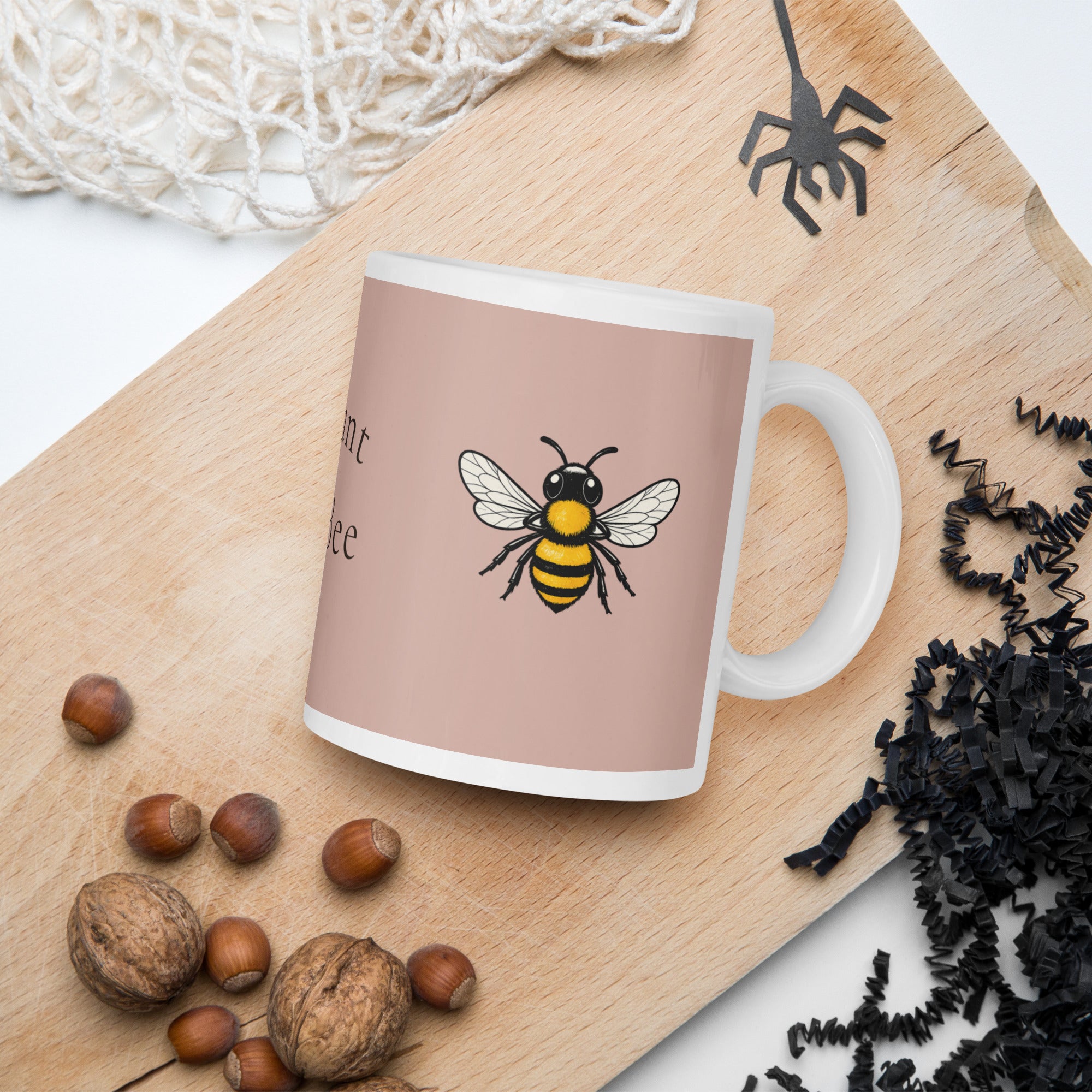 Dusty rose mug with white handle, rim, and small bee illustration on front panel
