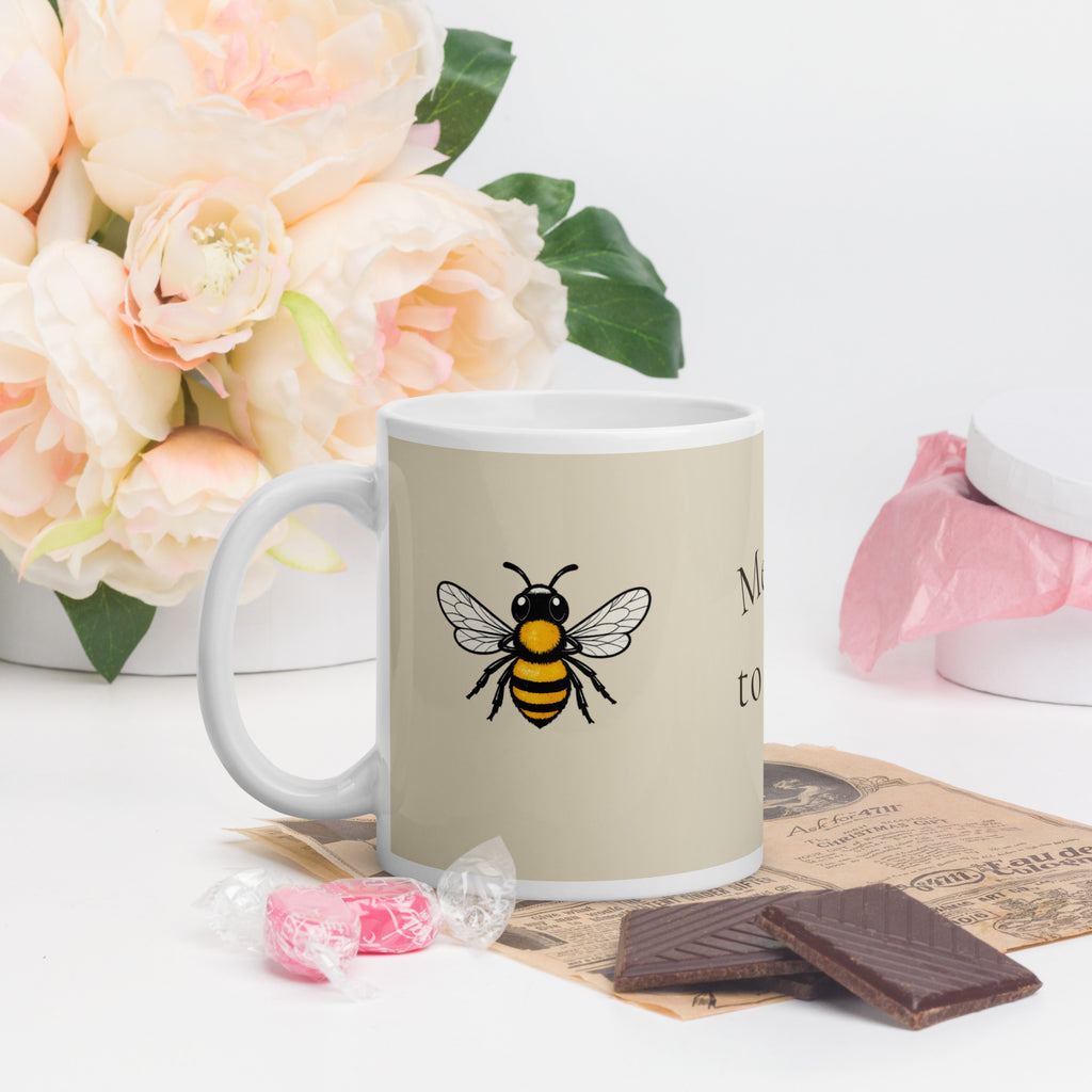 Light beige ceramic mug with bee illustration on light beige side