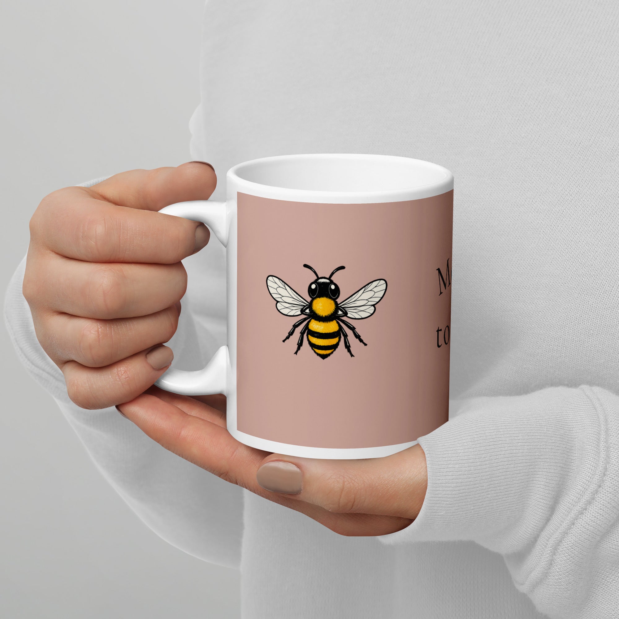 Dusty rose ceramic mug with white rim and bee illustration on front