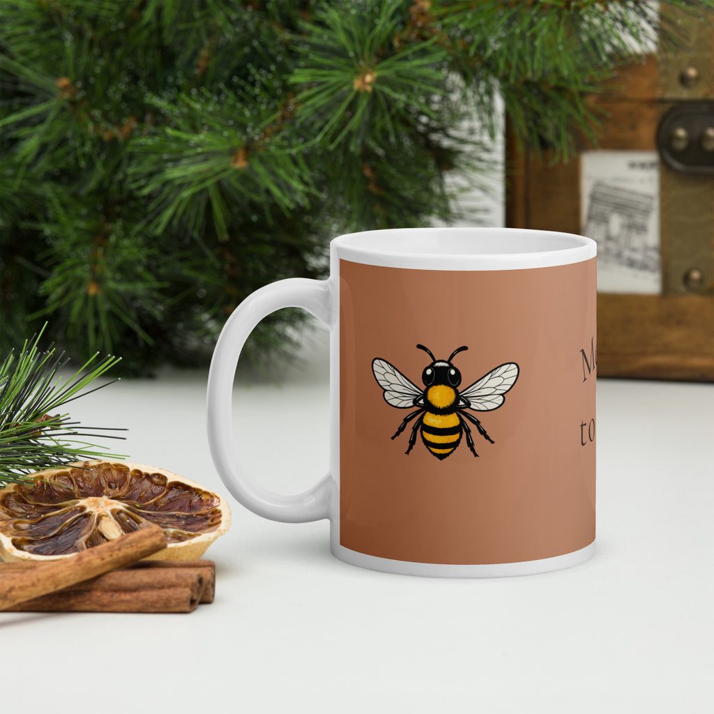 Brown ceramic mug with bee graphic, white rim and handle