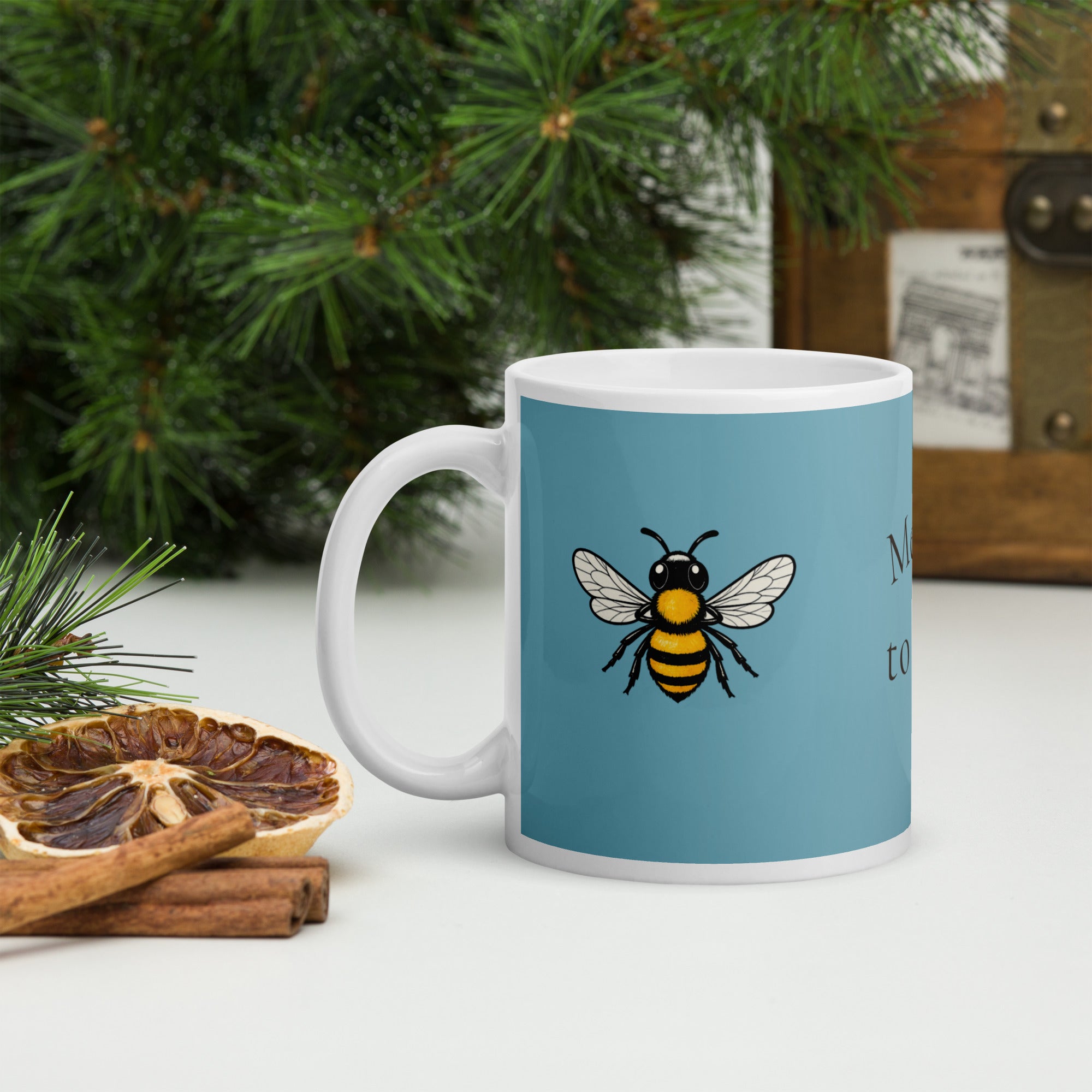 Blue ceramic mug with white handle and bee illustration, side view