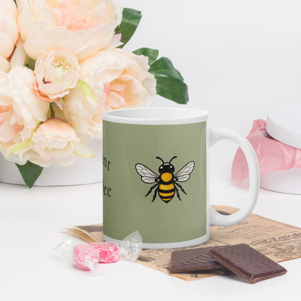 Sage green ceramic coffee mug with white handle and bee illustration, angled view