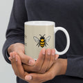 Light beige ceramic mug with bee illustration and white handle