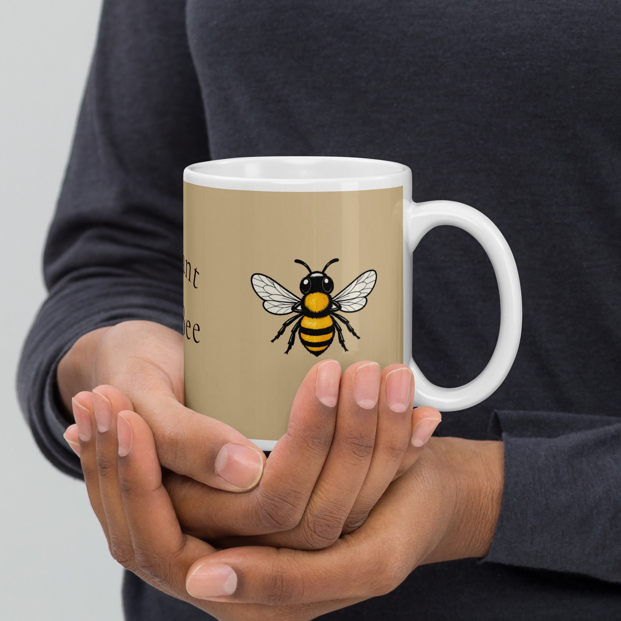 Beige ceramic coffee mug with bee illustration held in hands, white handle