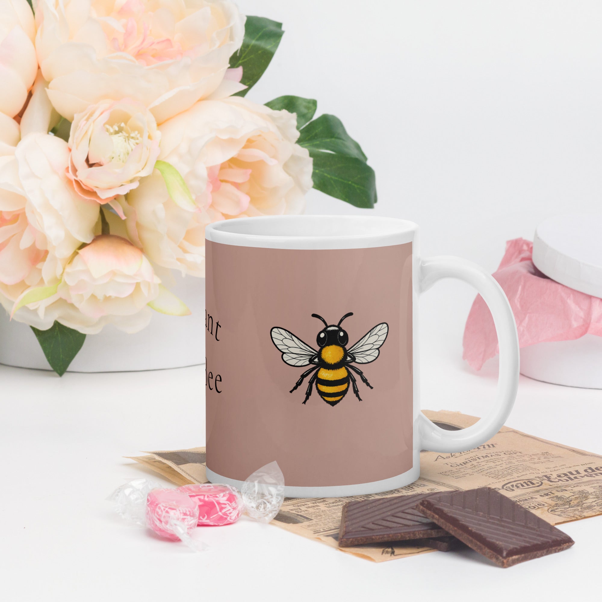 Dusty rose ceramic coffee mug with bee illustration on front panel.