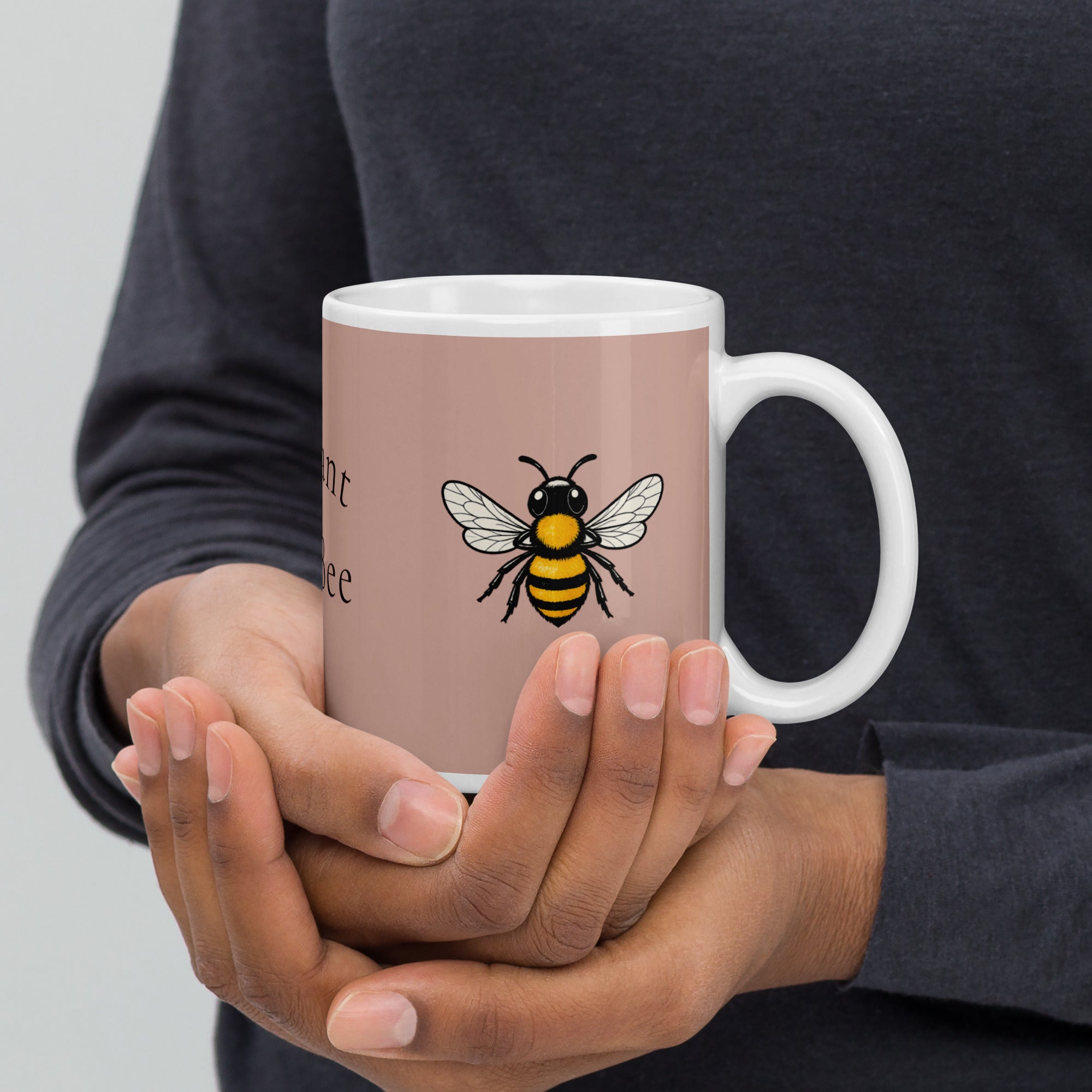 Dusty rose ceramic mug in hands with bee illustration, white handle and rim