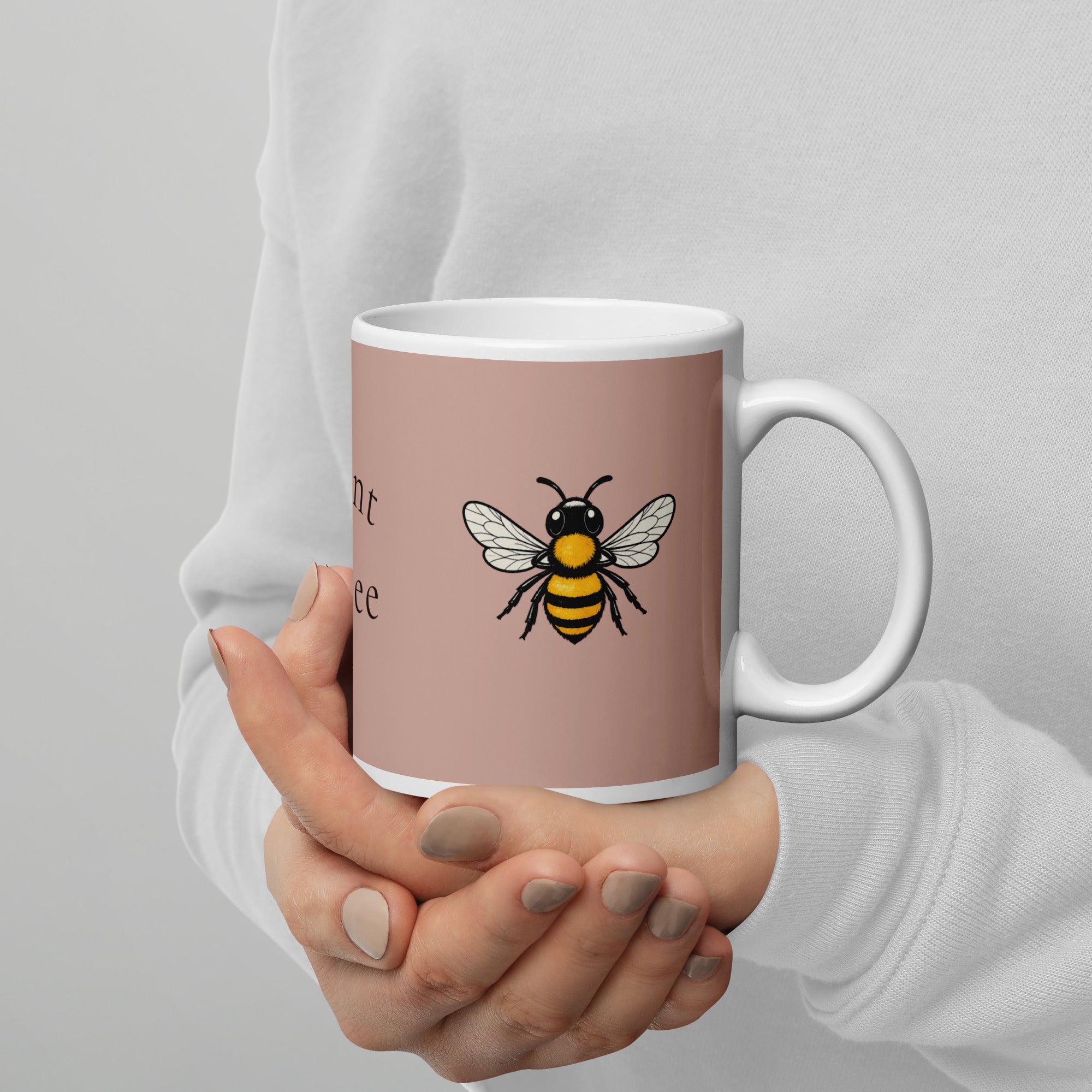Dusty rose ceramic mug with bee illustration held in hands, white handle