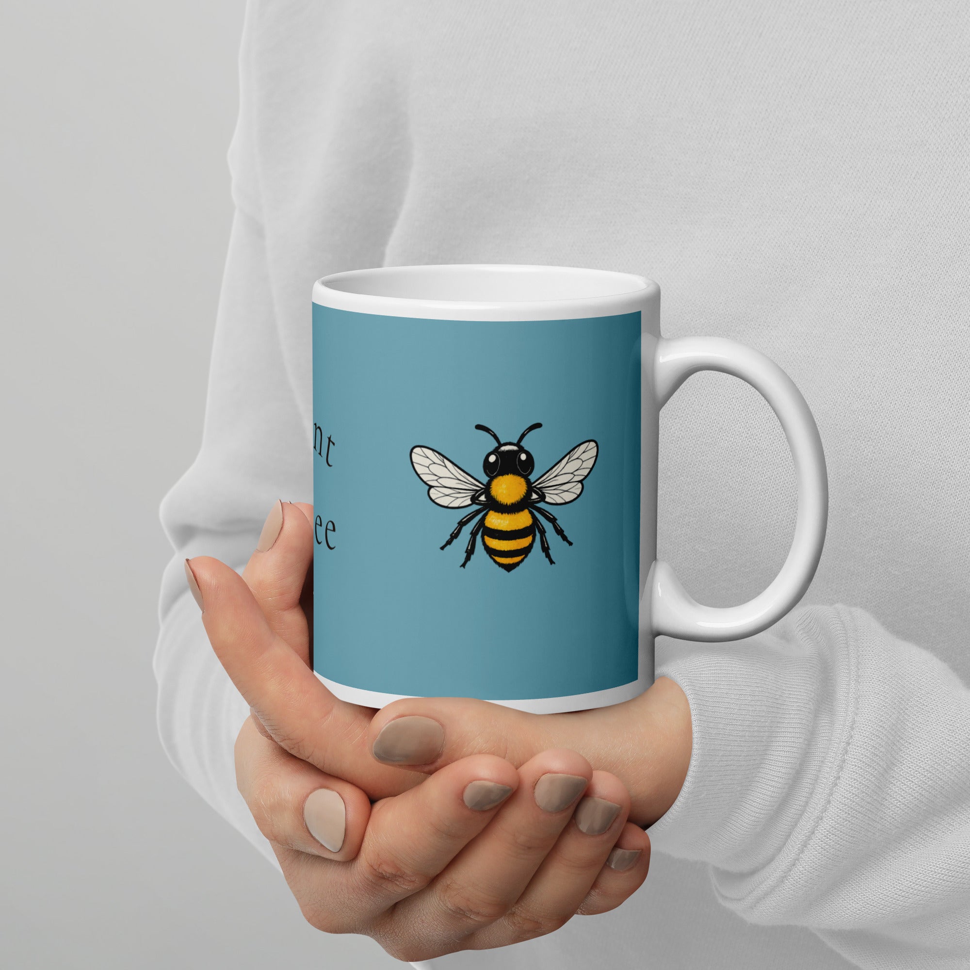 Blue ceramic mug with white rim and handle, bee illustration held close to the body