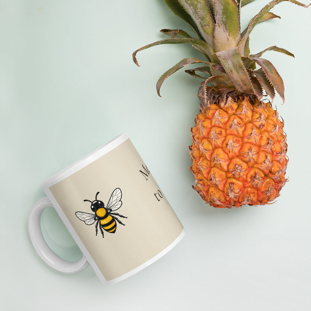 Light beige ceramic mug with bee illustration, tilted on a surface