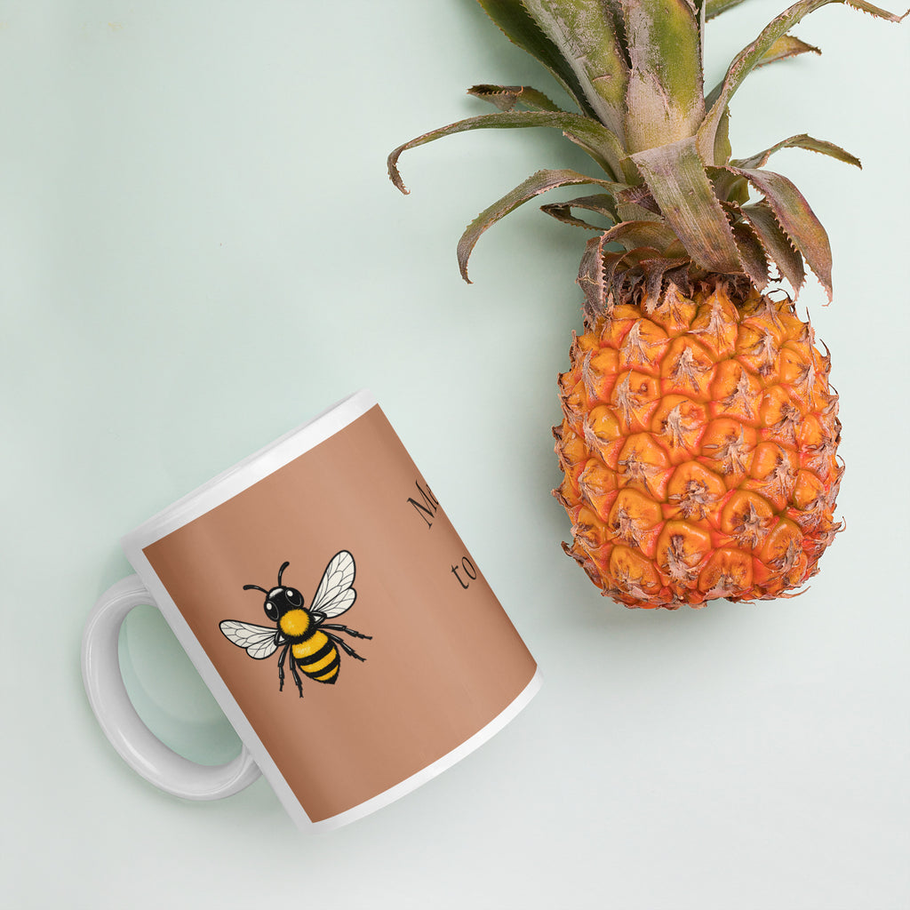Brown ceramic mug with bee illustration; tilted view on tabletop